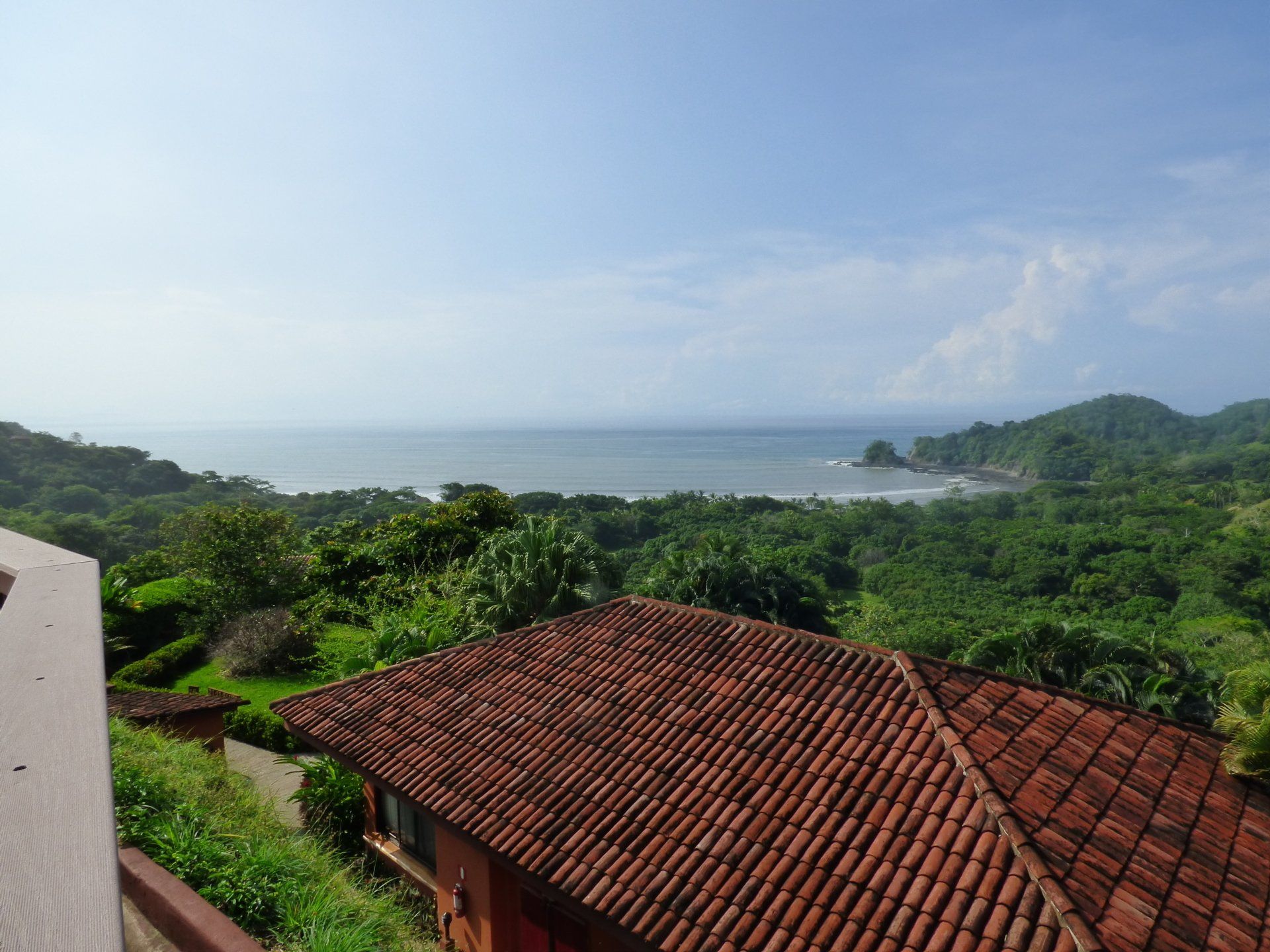 A view of the ocean from a house with a tiled roof