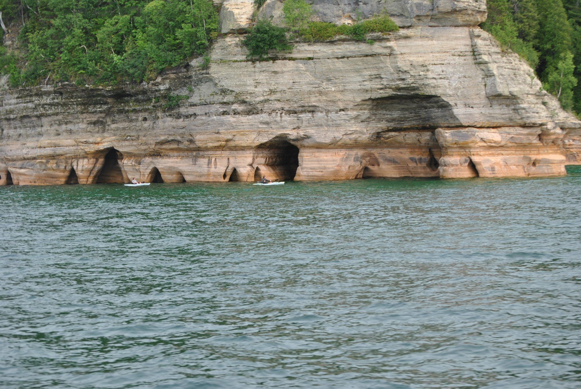 A body of water with a cliff in the background
