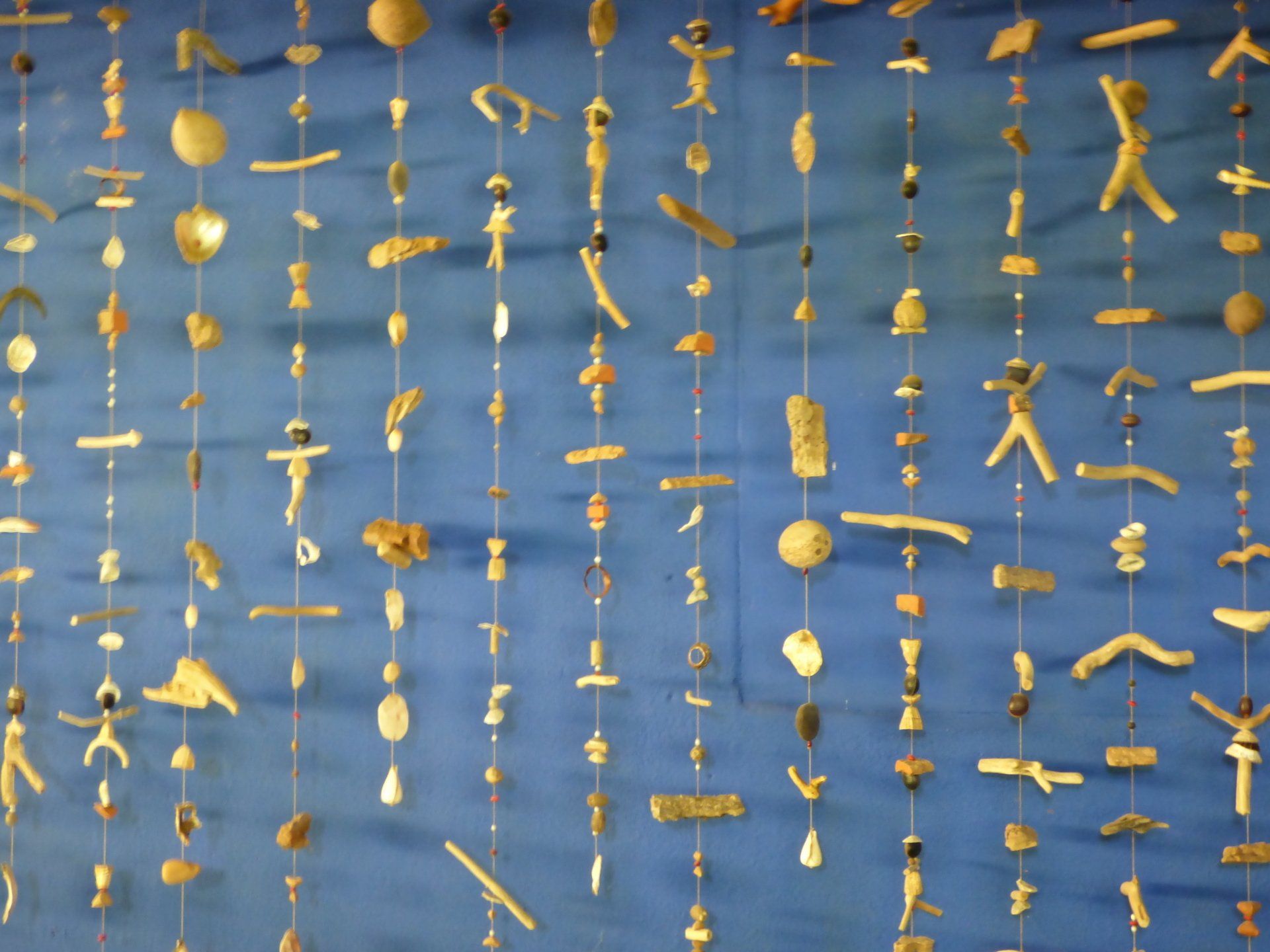 A row of strings hanging from a blue wall