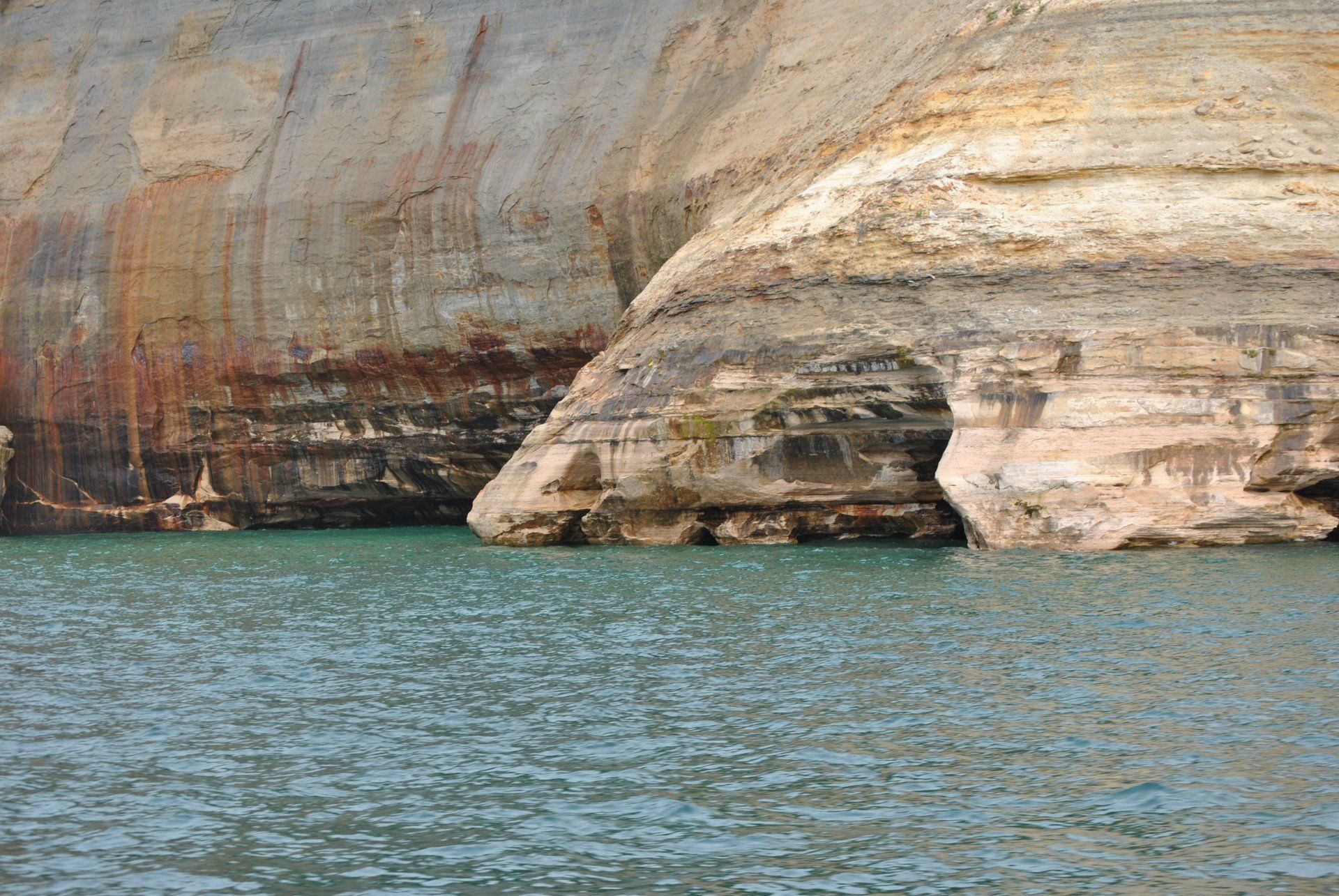 A large rock formation in the middle of a body of water.