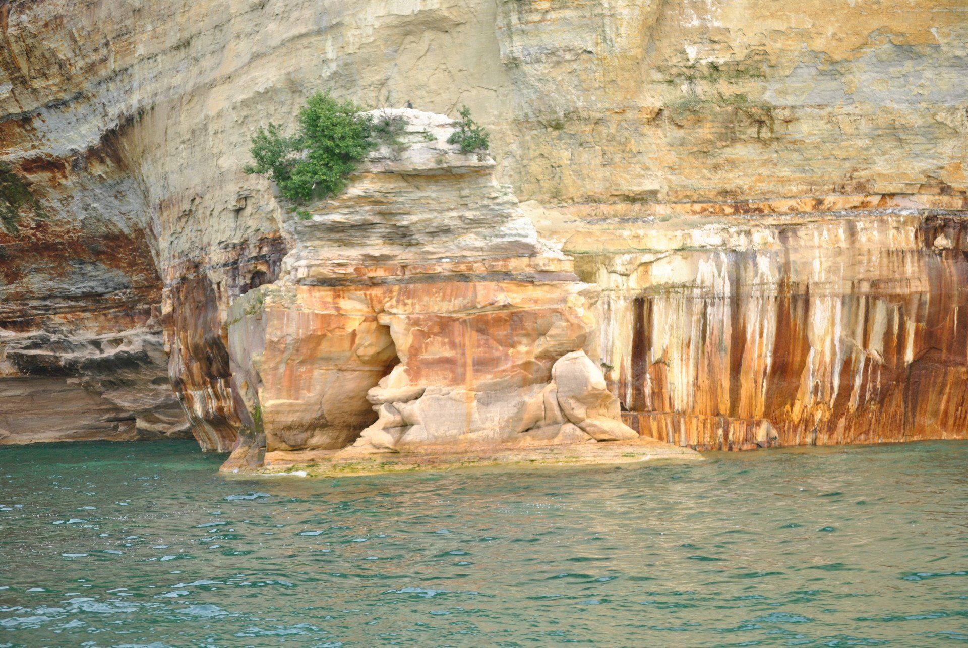 A large rock formation in the middle of a body of water.