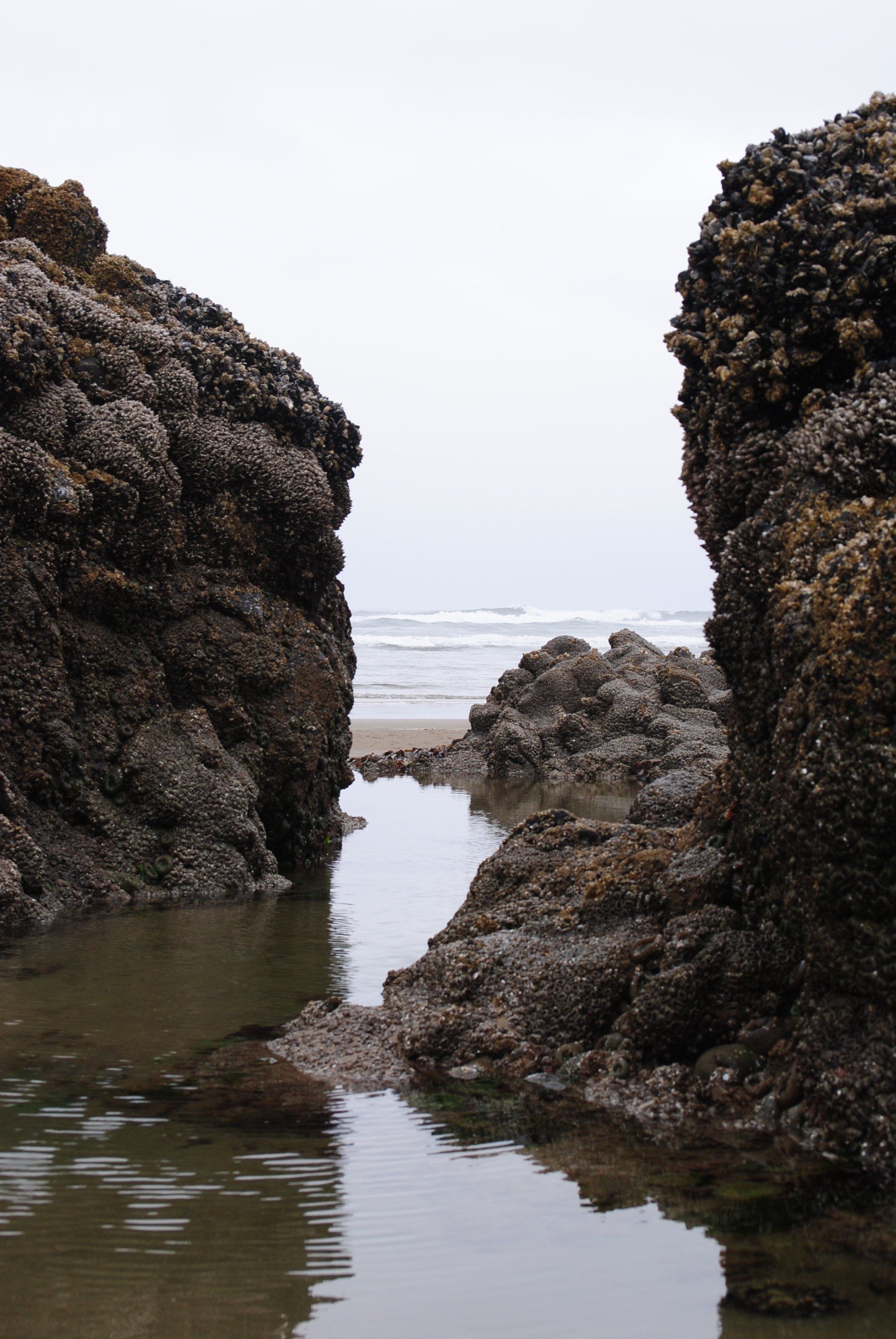 A body of water between two rocks on a beach