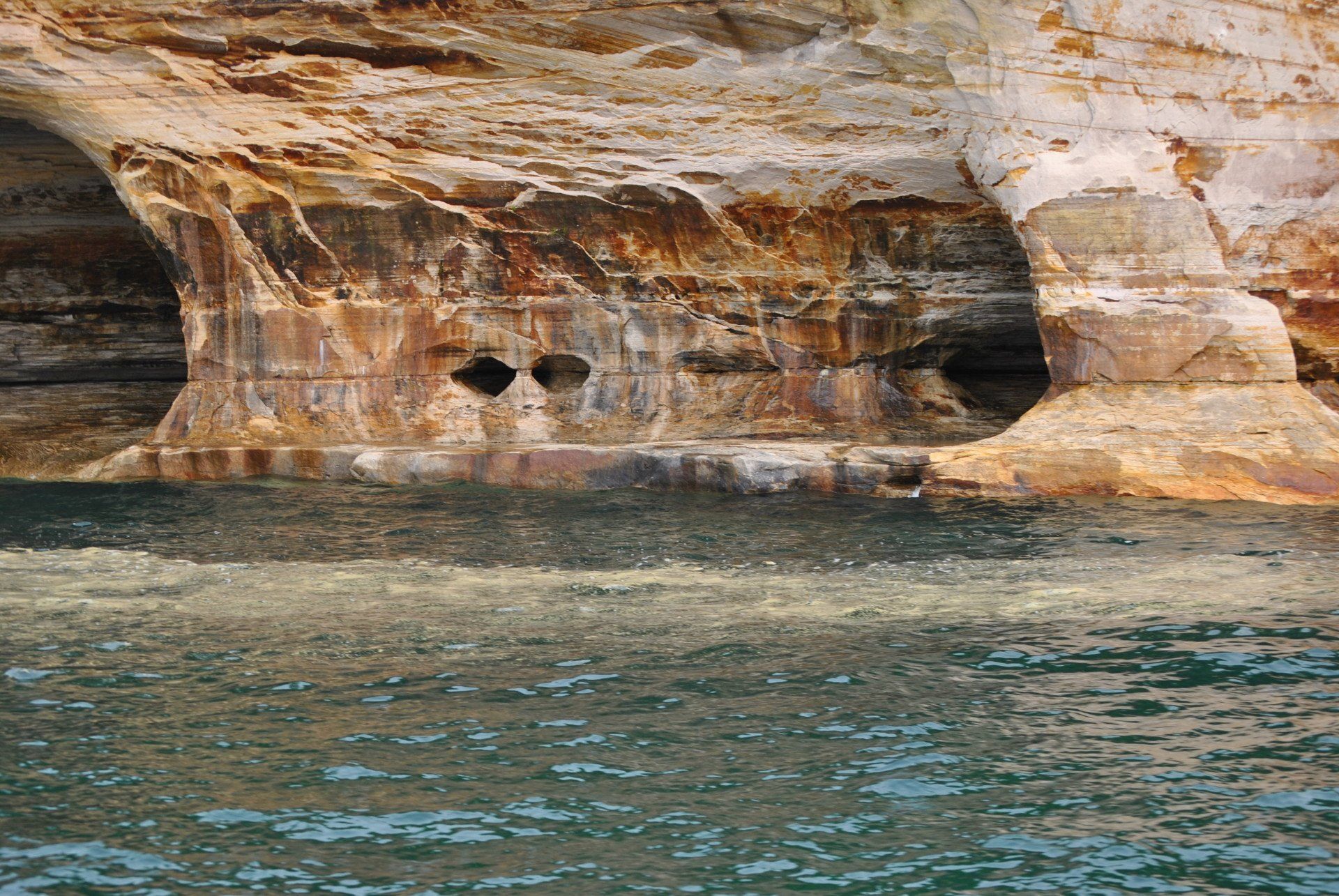 A large rock formation in the middle of a body of water
