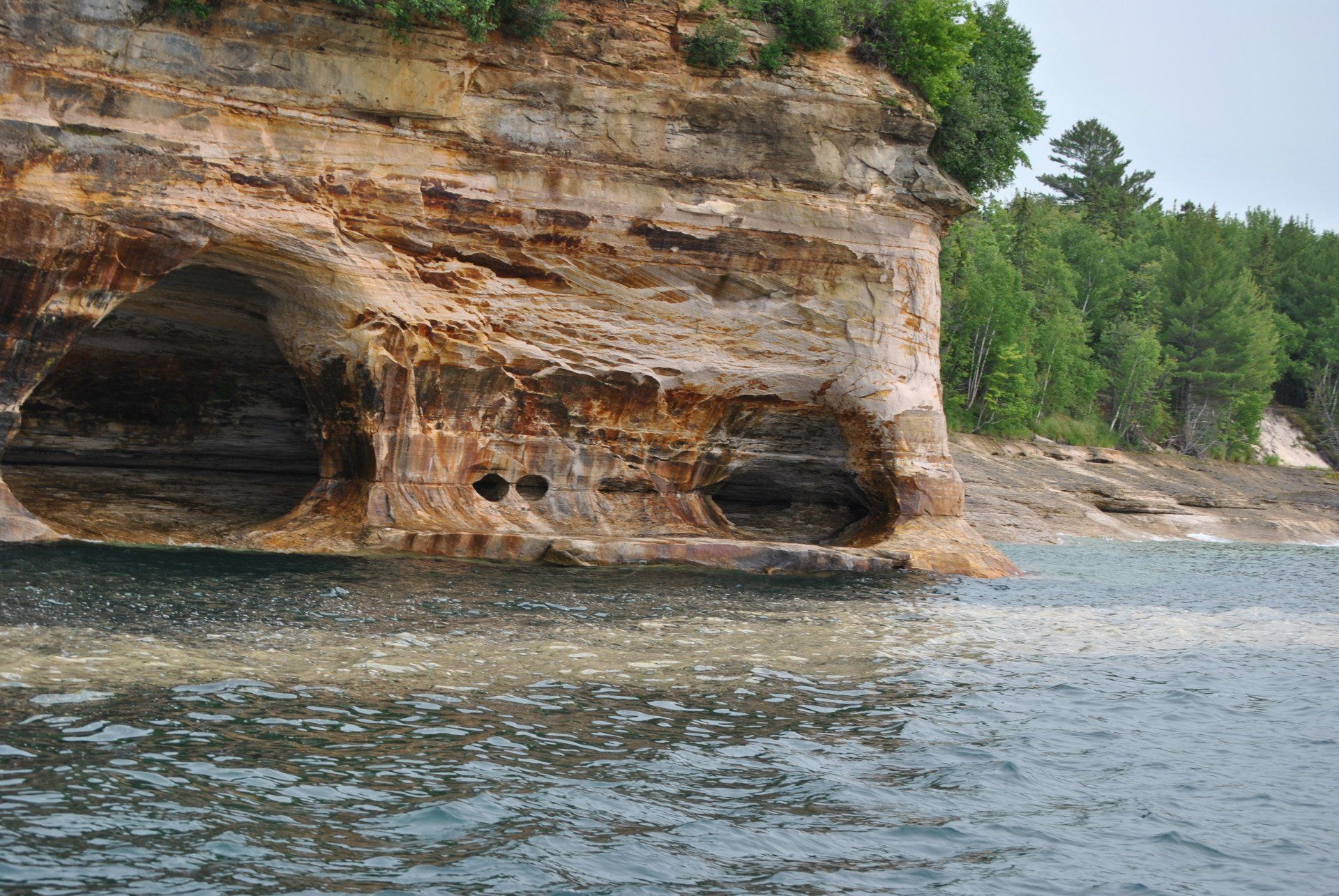 A large rock formation in the middle of a body of water