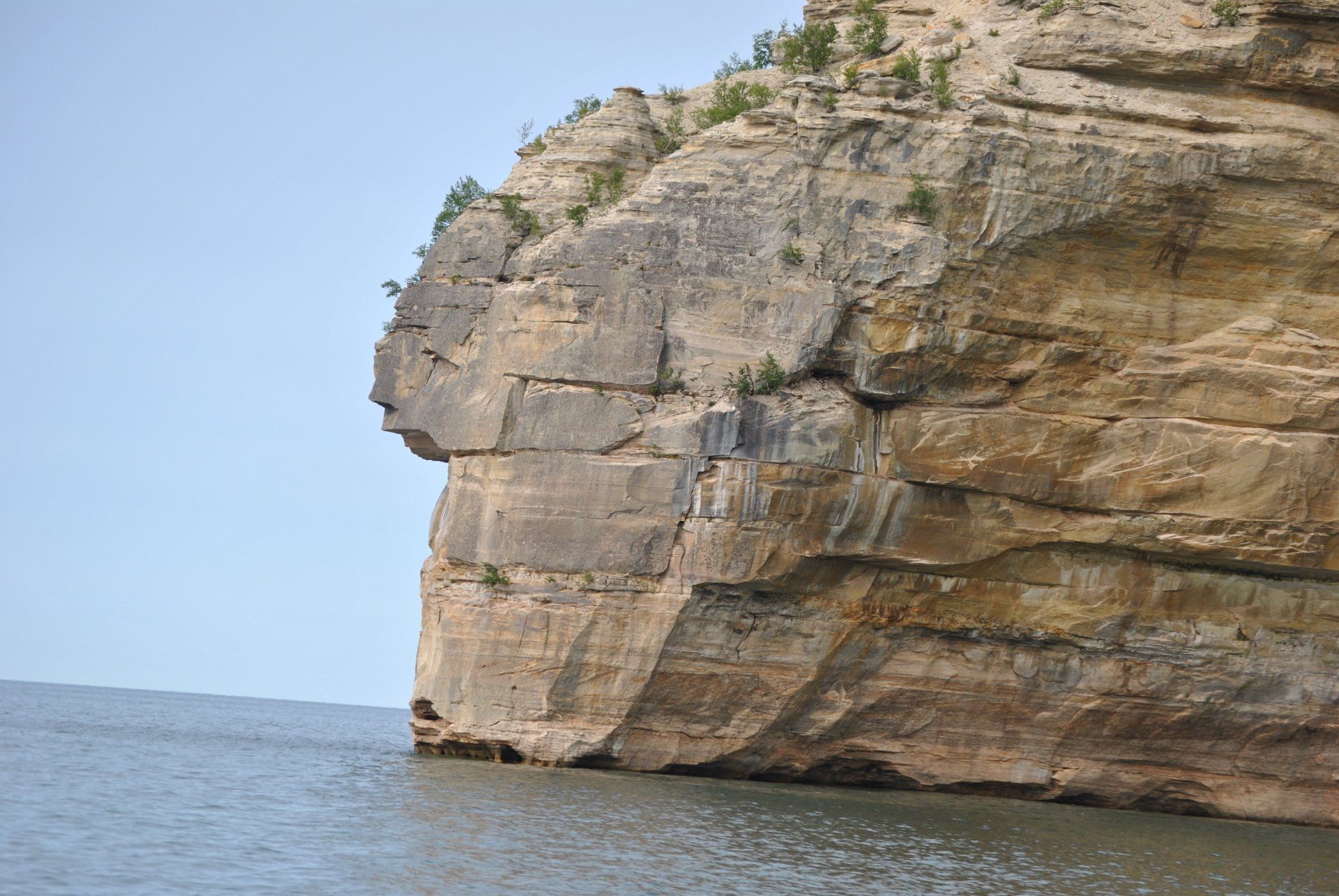 A large rock formation in the middle of a body of water