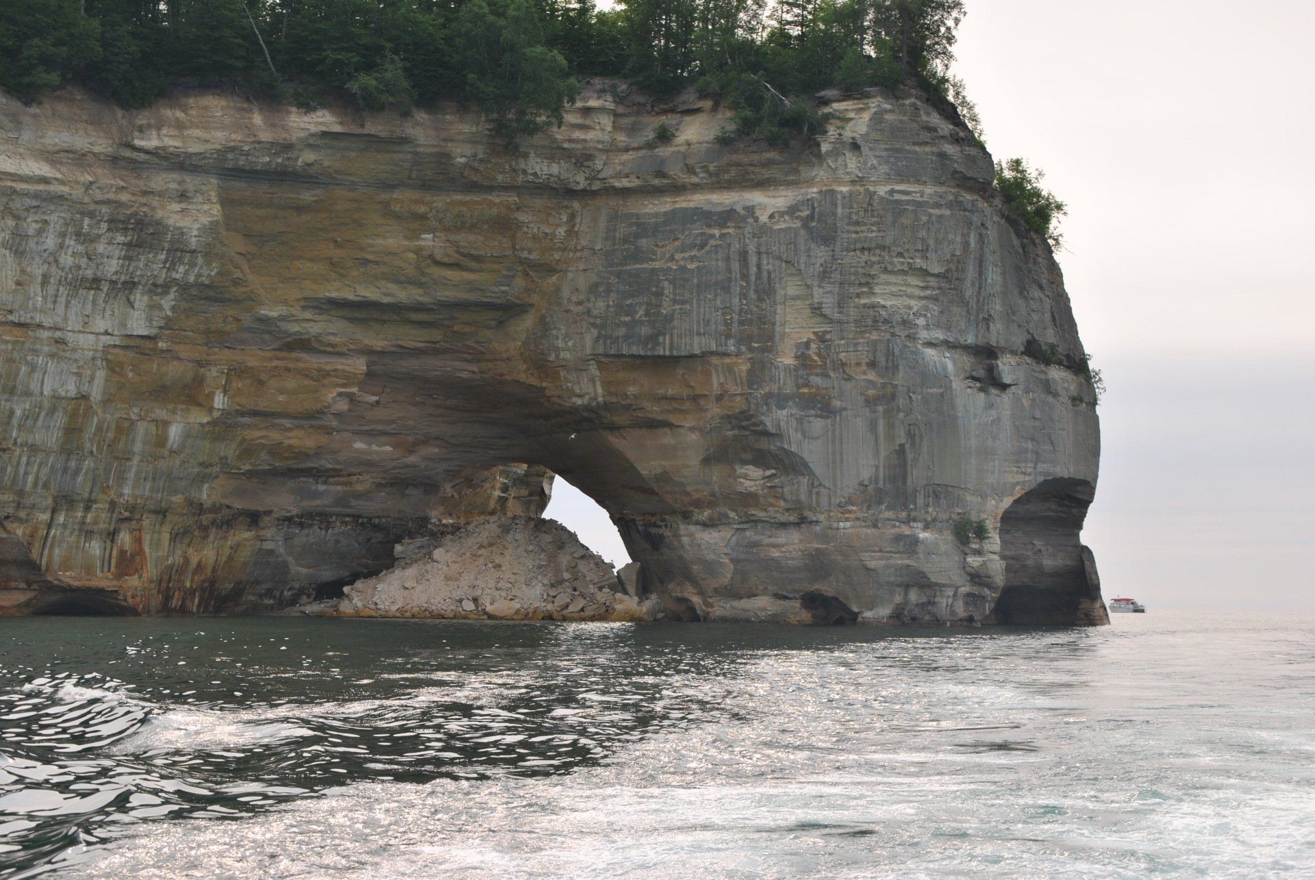 A large rock formation in the middle of a body of water.
