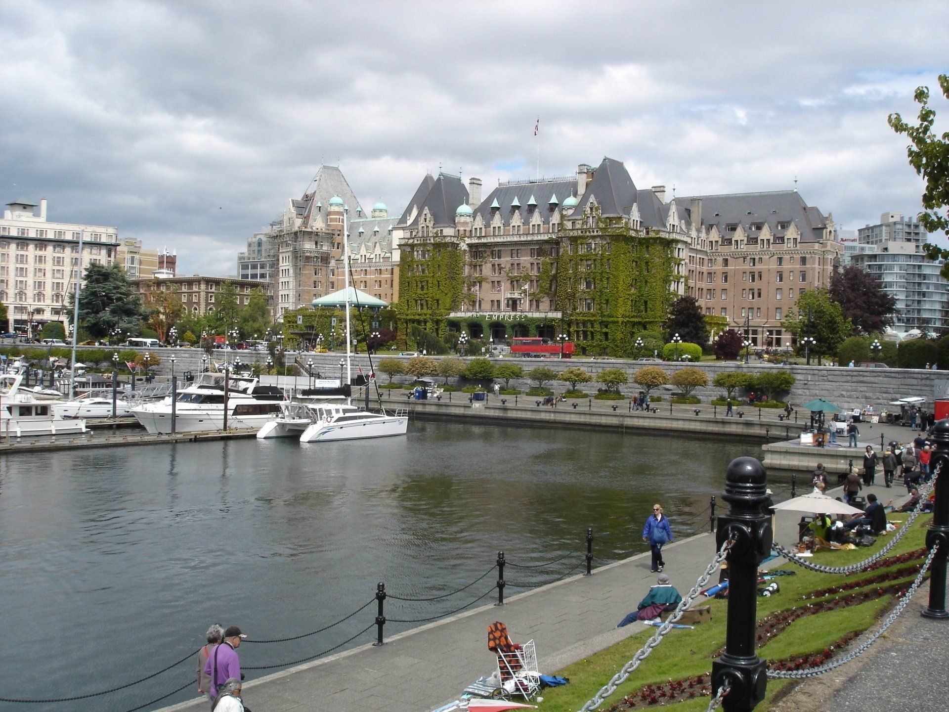 Boats are docked in a harbor with a large building in the background