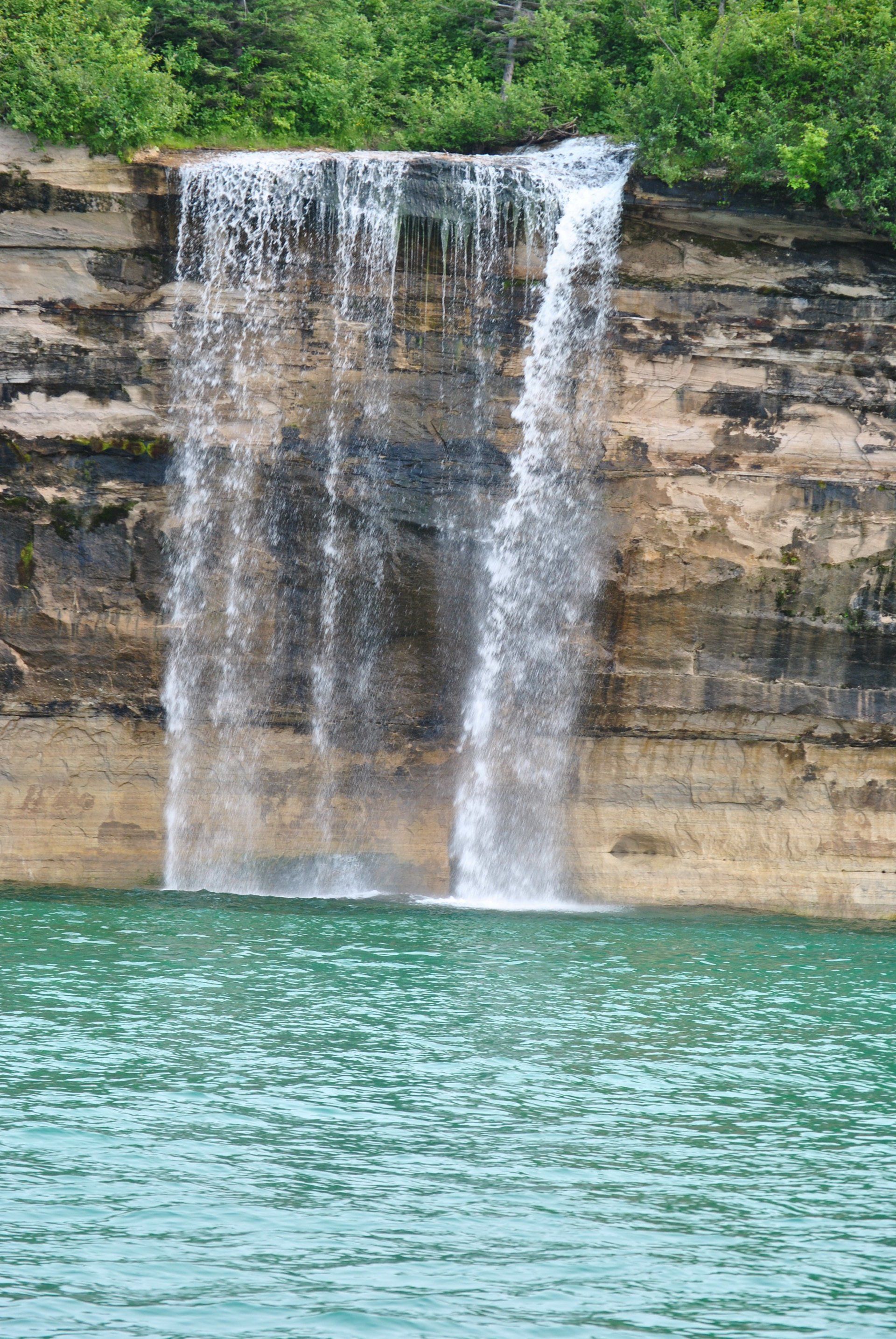 A waterfall is falling into a body of water
