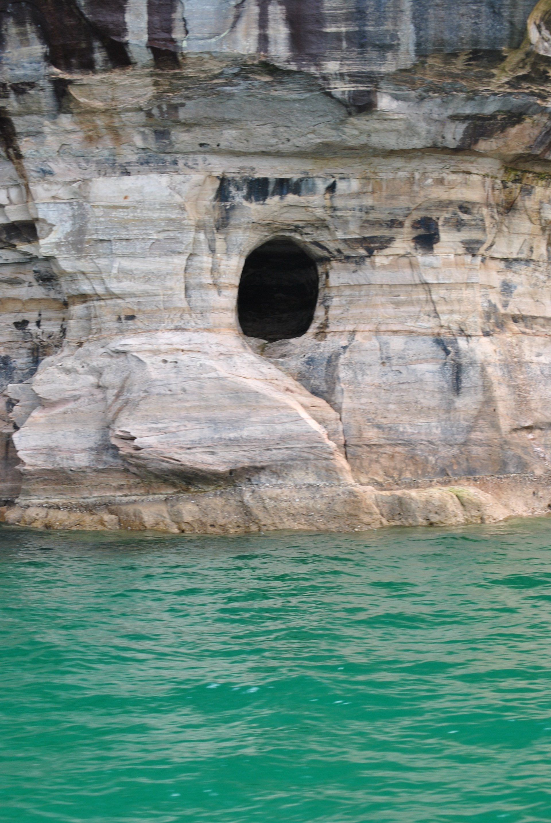 There is a hole in the rock in the water.