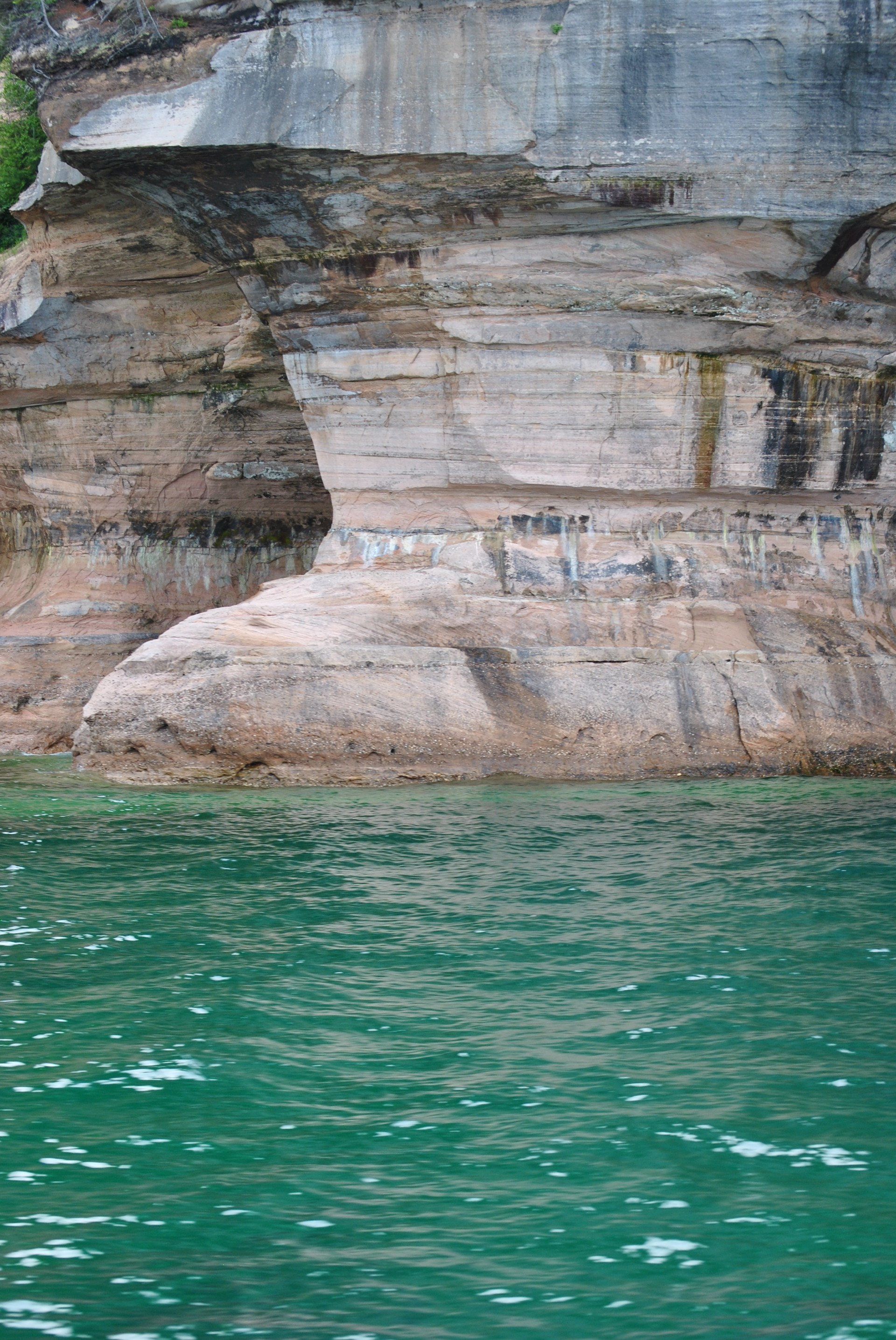 A large rock formation in the middle of a body of water.