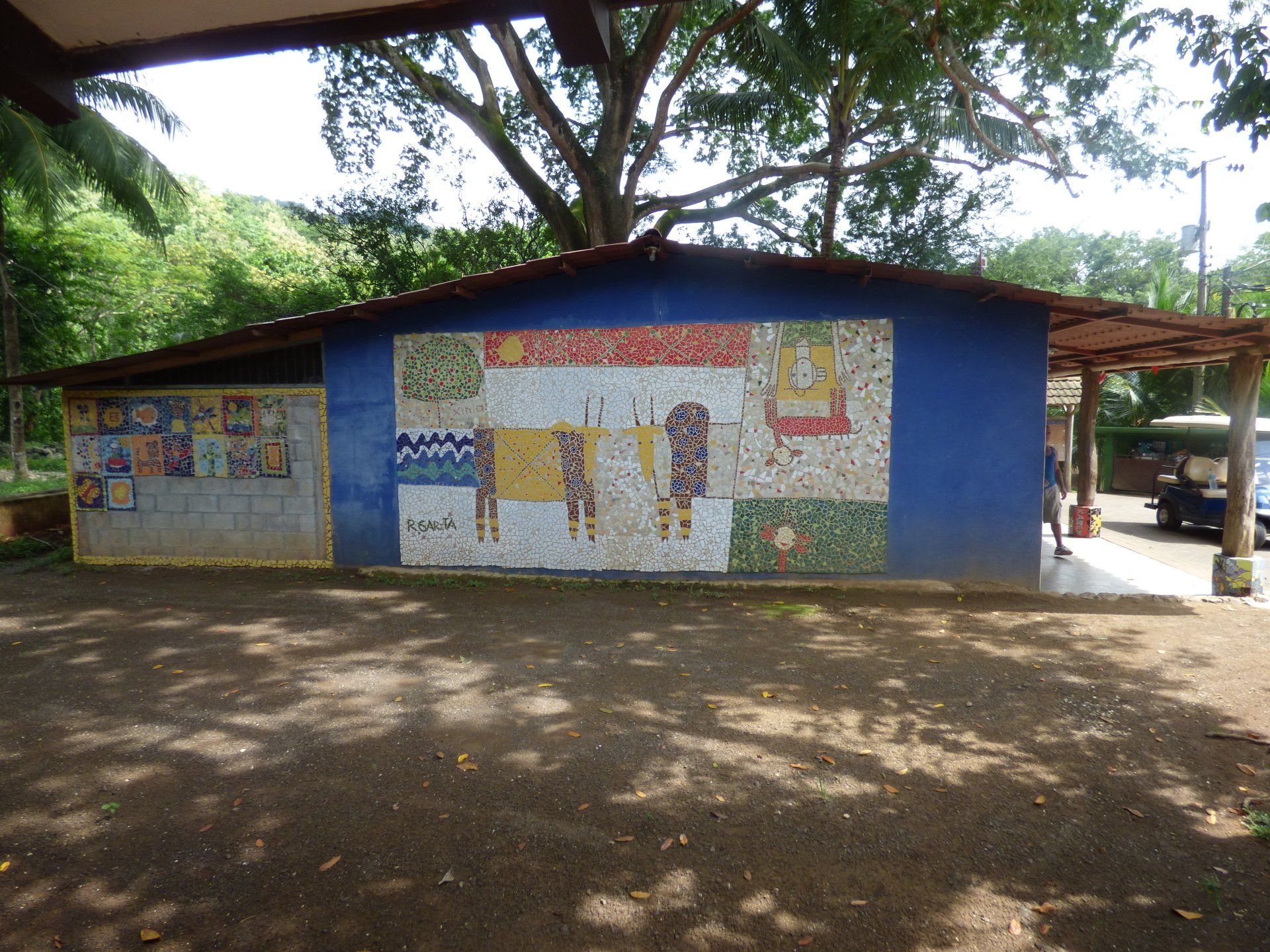 A blue building with a mosaic on the side of it