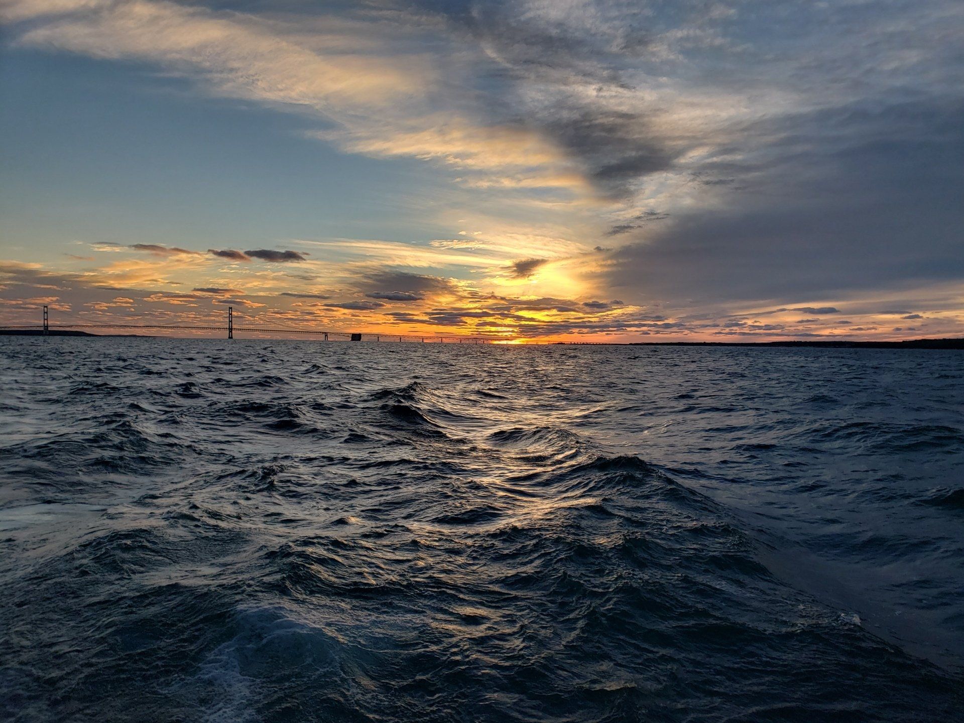 A view of the ocean at sunset from a boat.