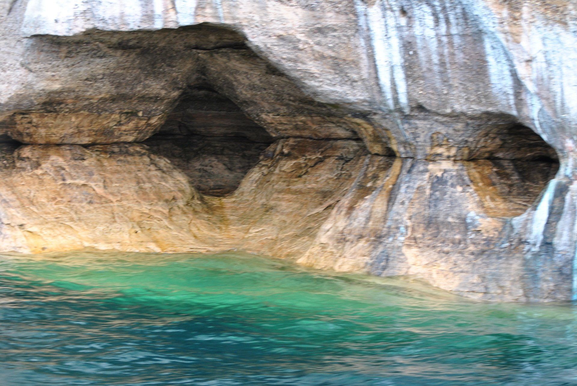 There is a cave in the rocks that looks like a cave in the water.
