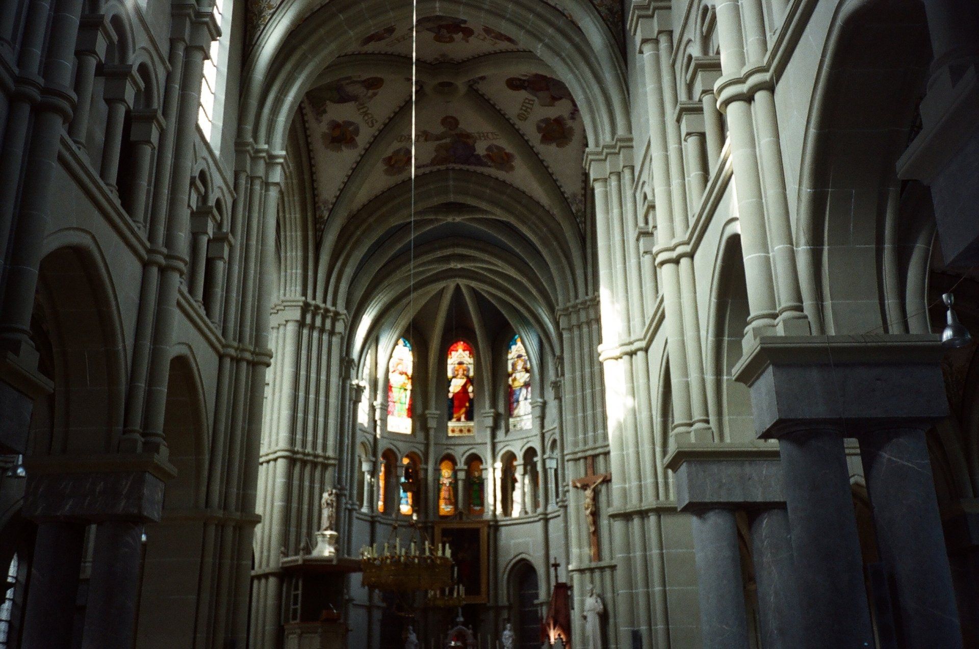 The inside of a church with arches and stained glass windows