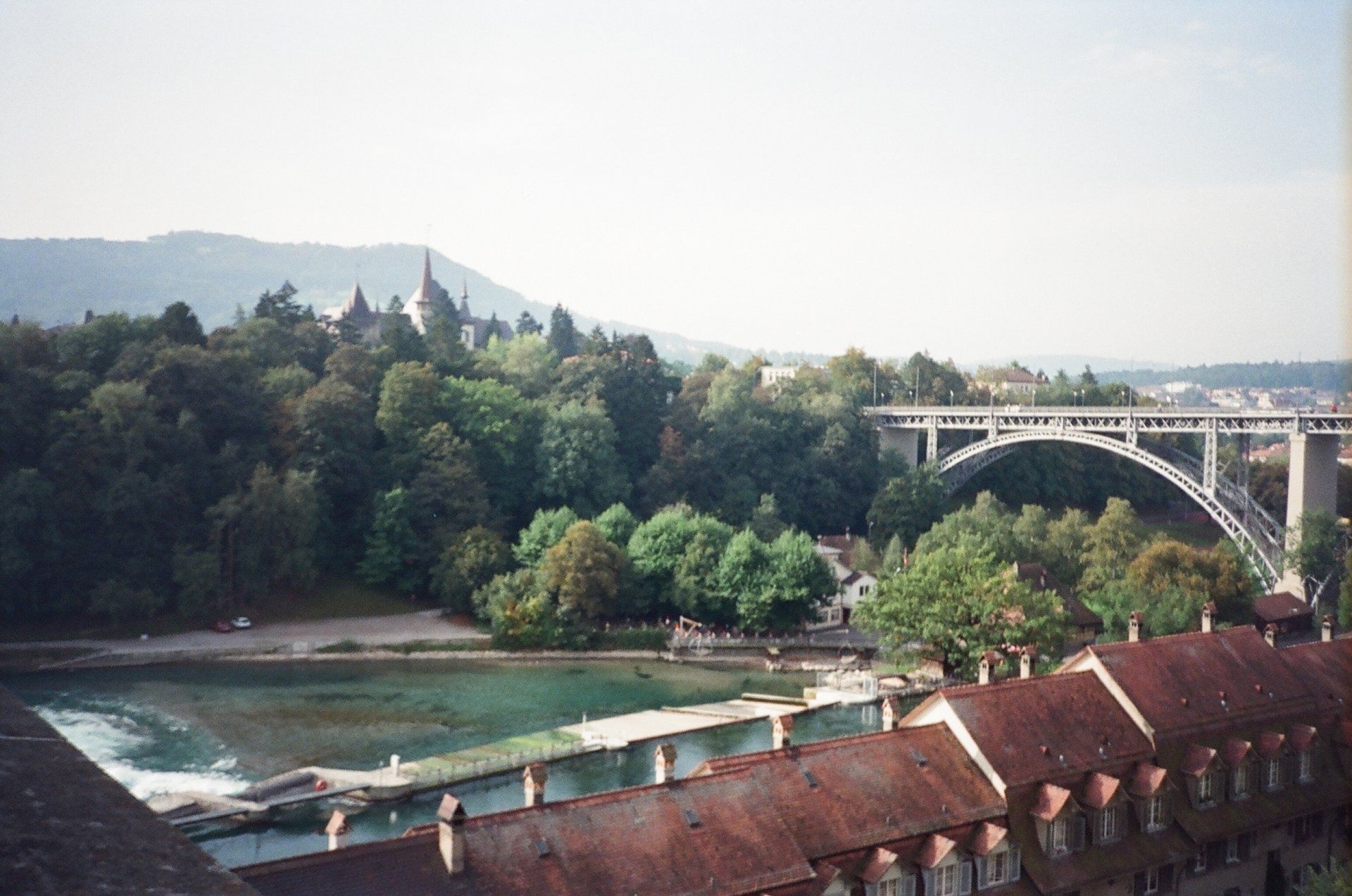 A bridge over a river surrounded by trees and buildings