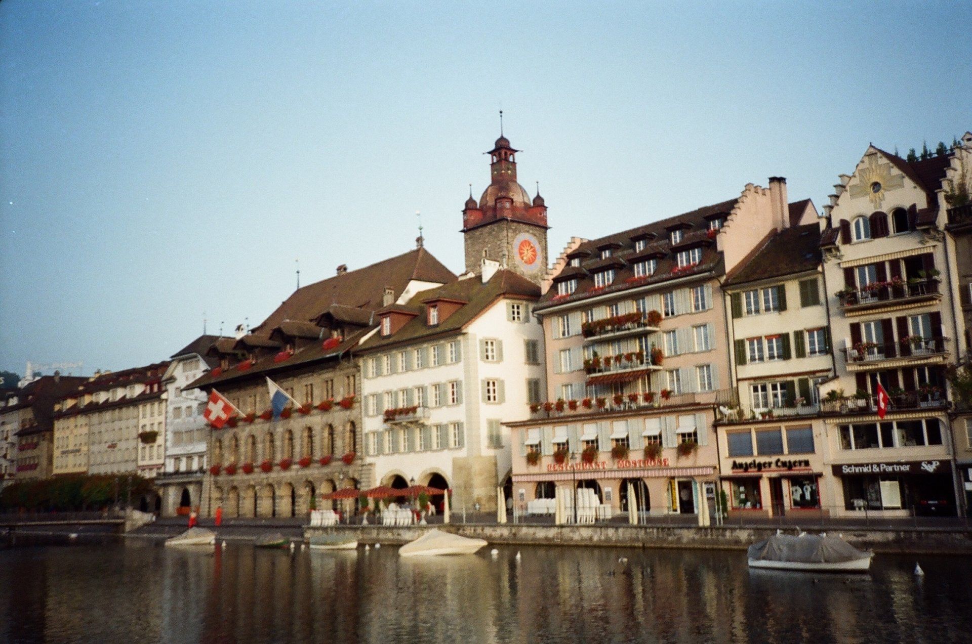 A row of buildings next to a body of water with a clock tower