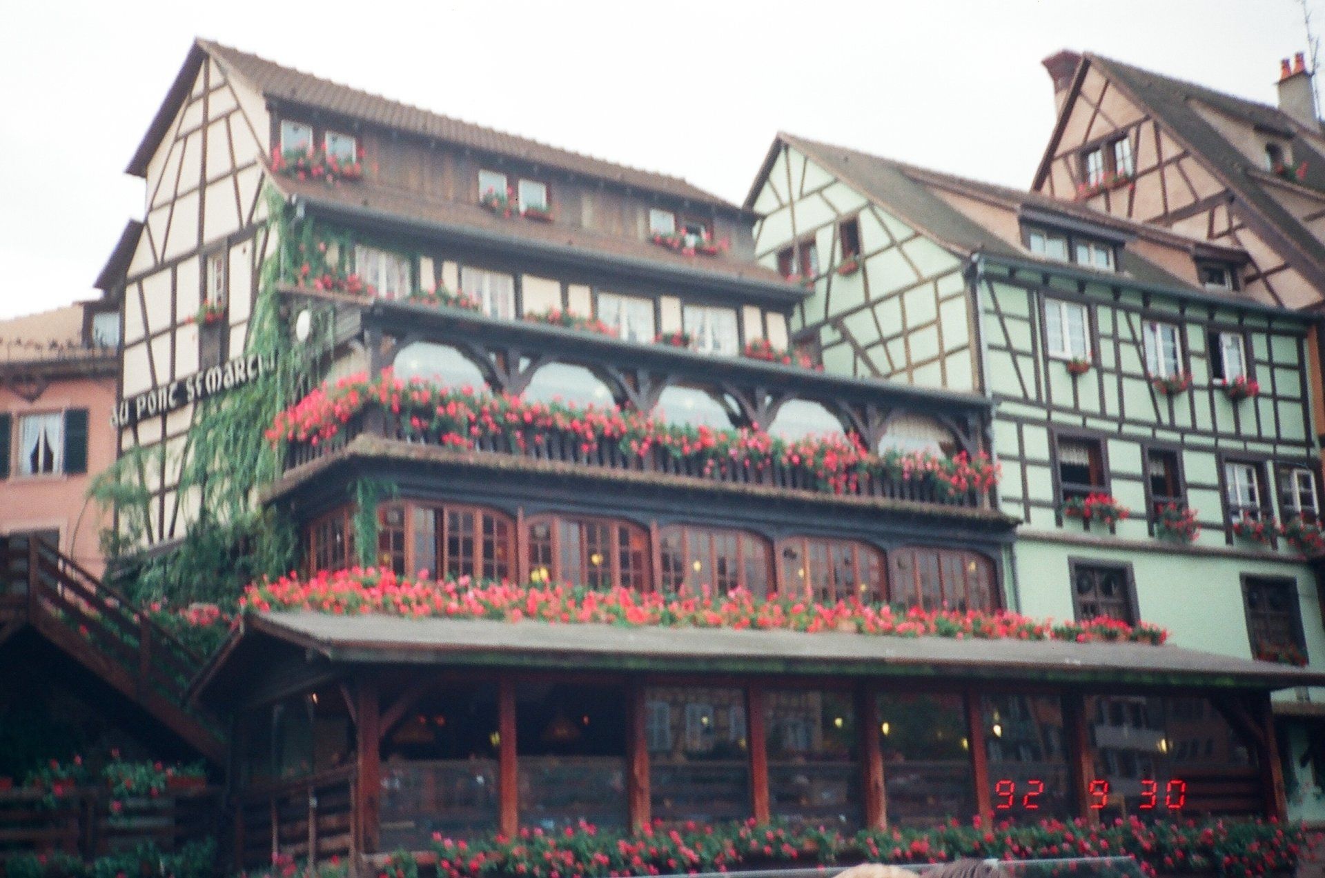 A large building with a balcony and flowers in front of it