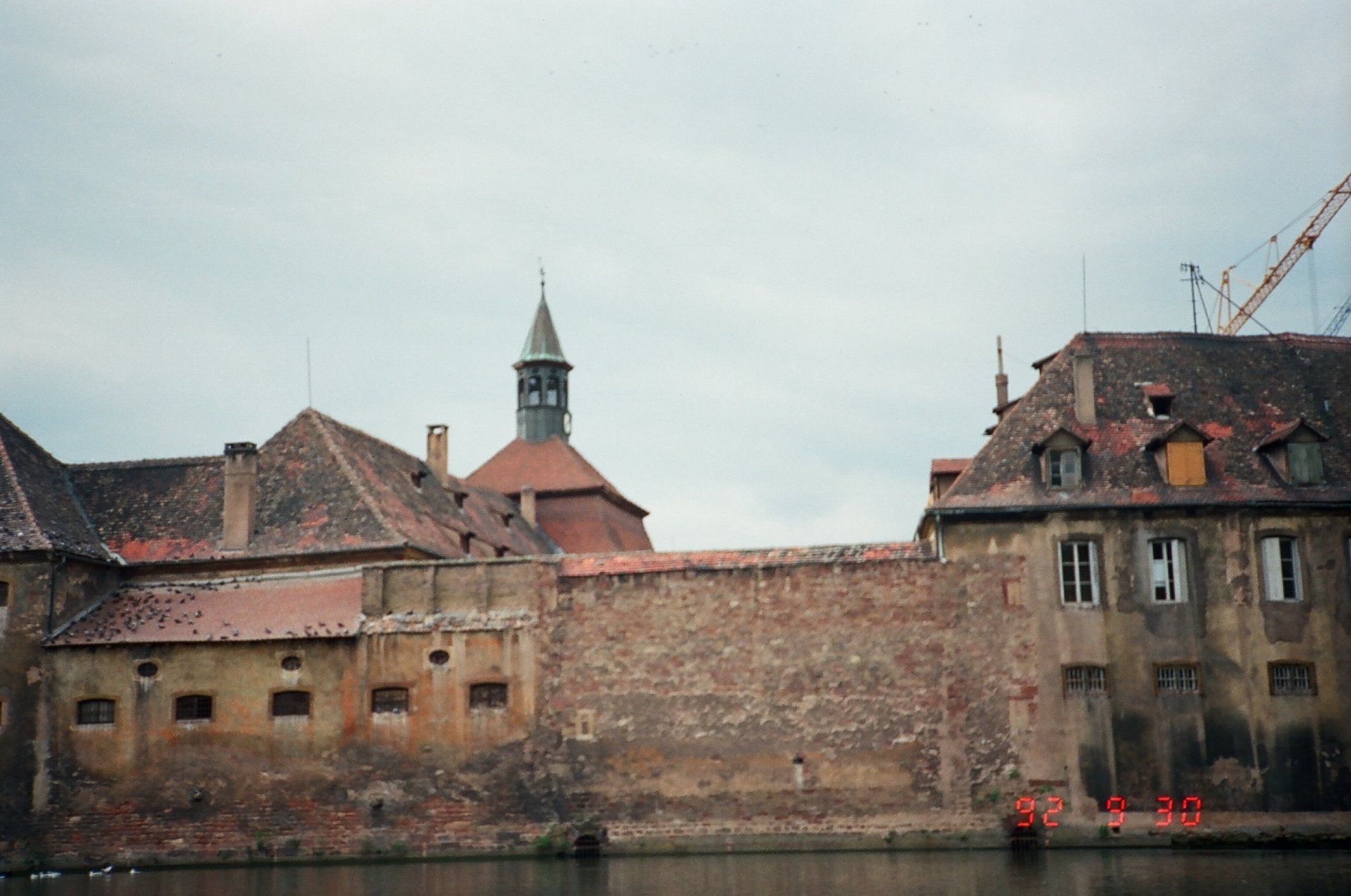 A building with a tower on top of it is next to a body of water.