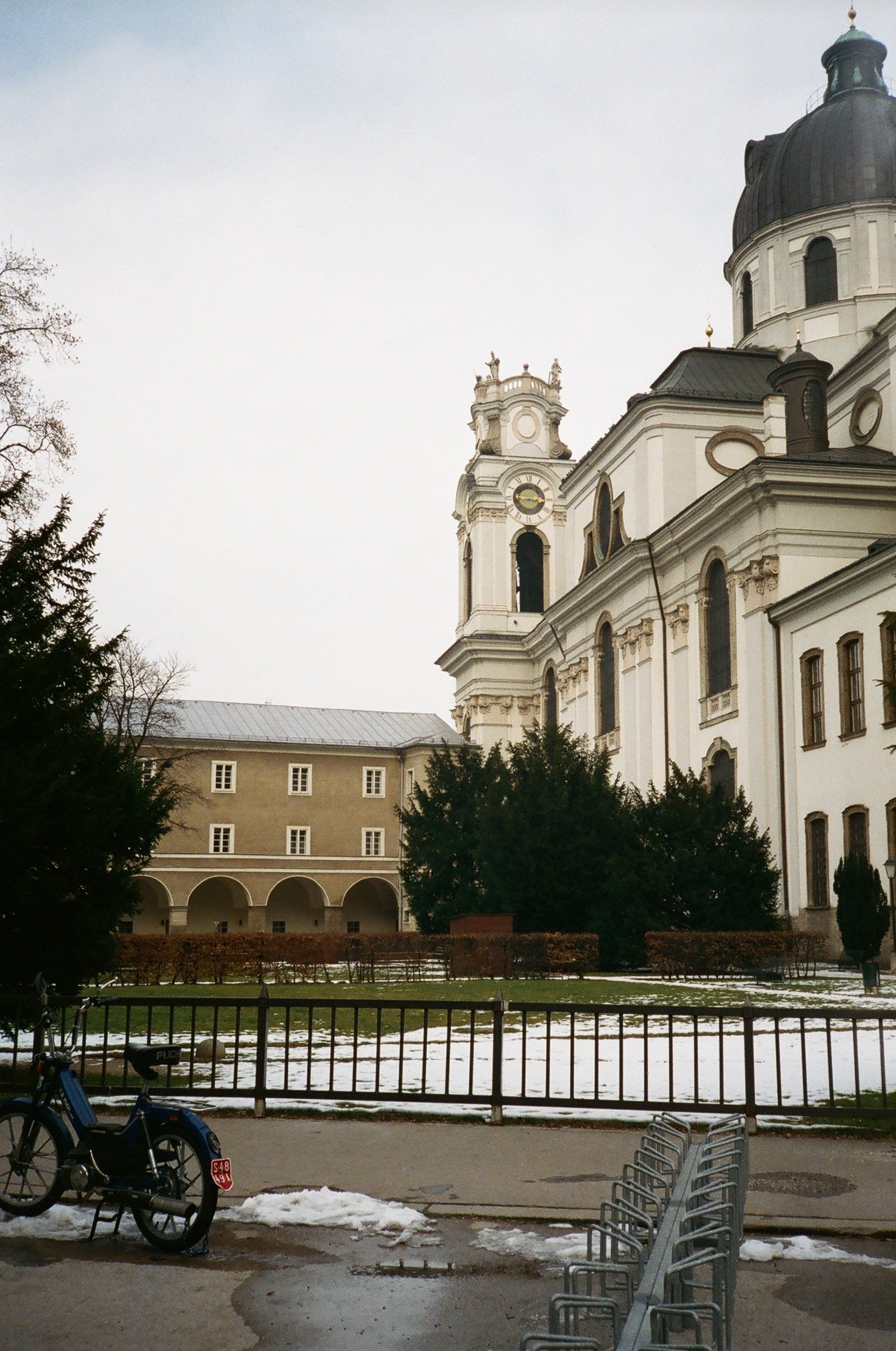 A motorcycle is parked in front of a large building