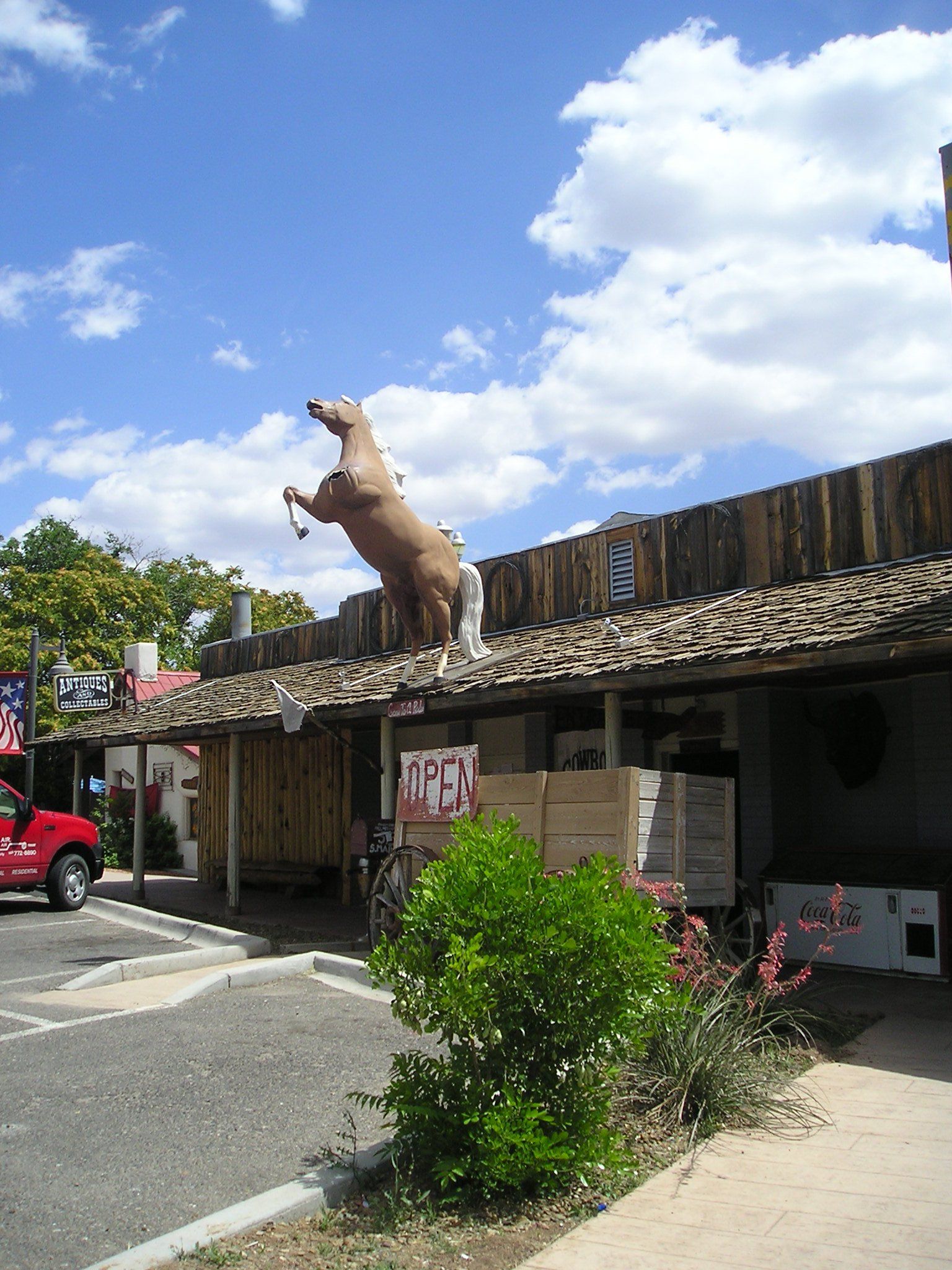 A statue of a horse is on the roof of a building
