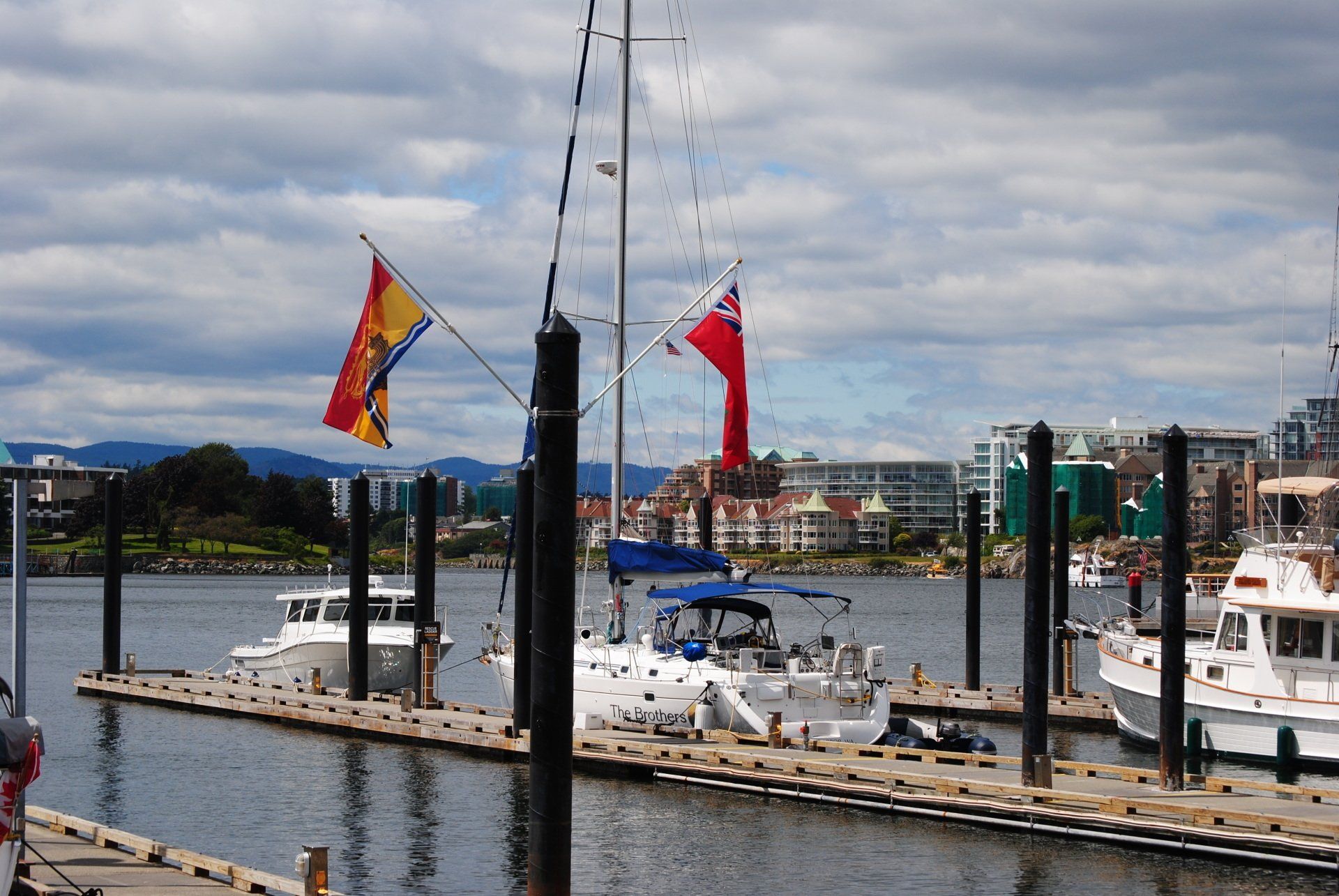 Several boats are docked in a harbor with flags flying