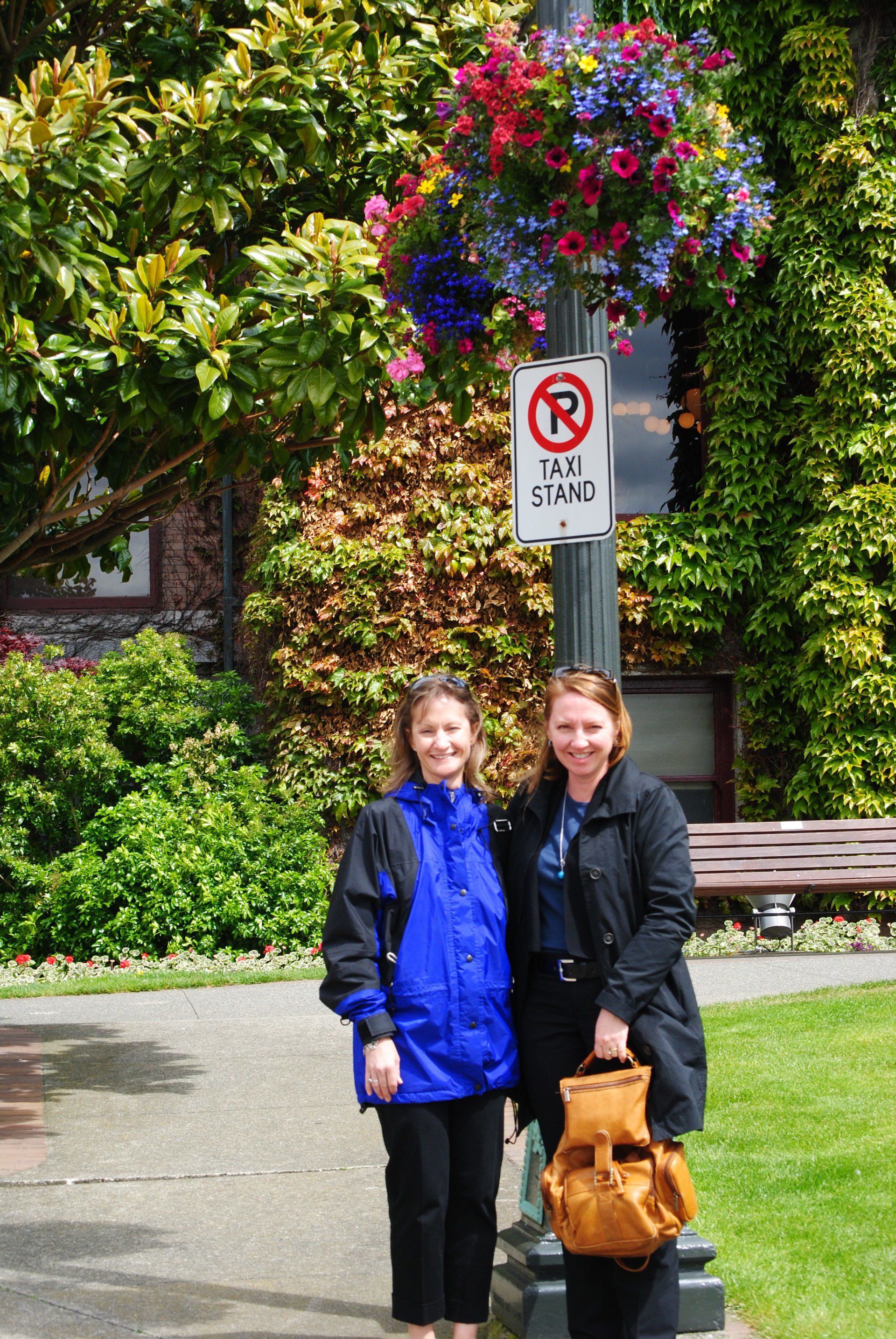 Two women standing in front of a no parking sign