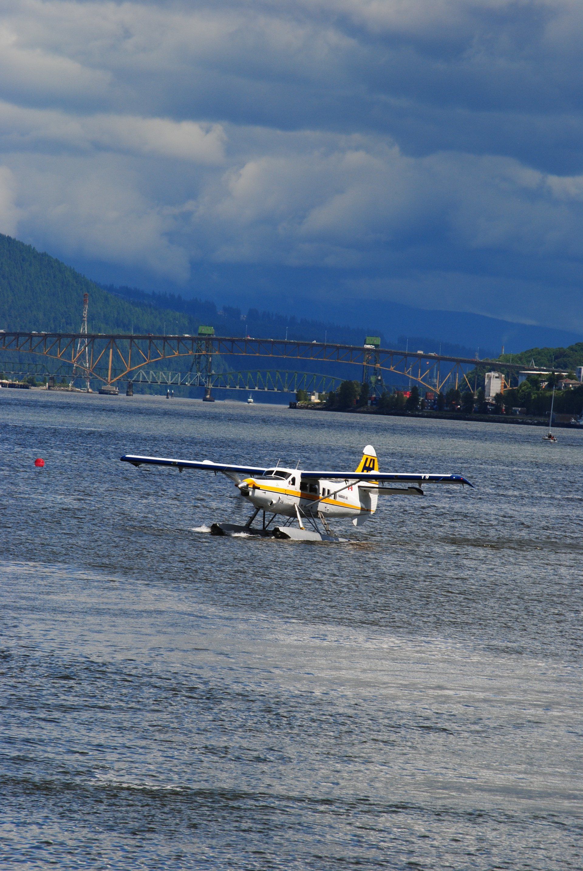 A small plane is flying over a body of water.