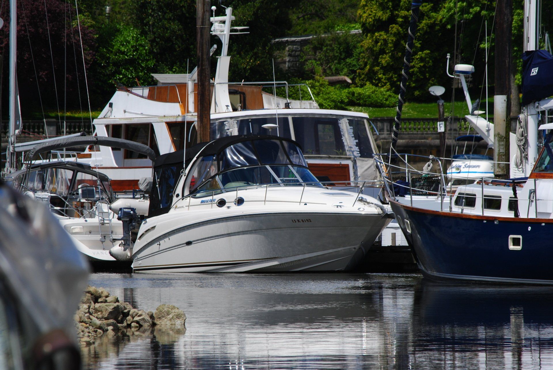 A boat is docked in a marina with other boats