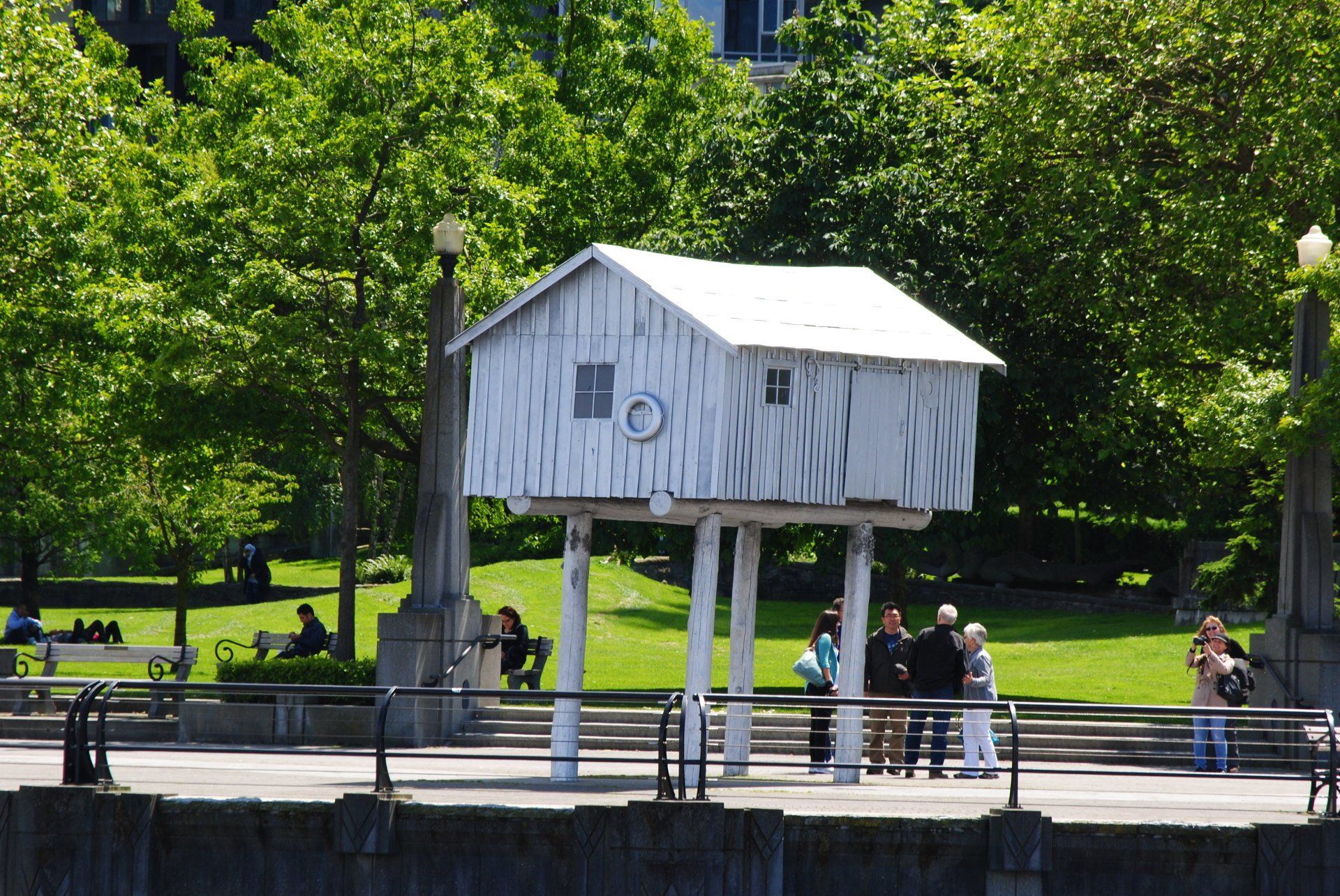 A small white house on stilts in a park