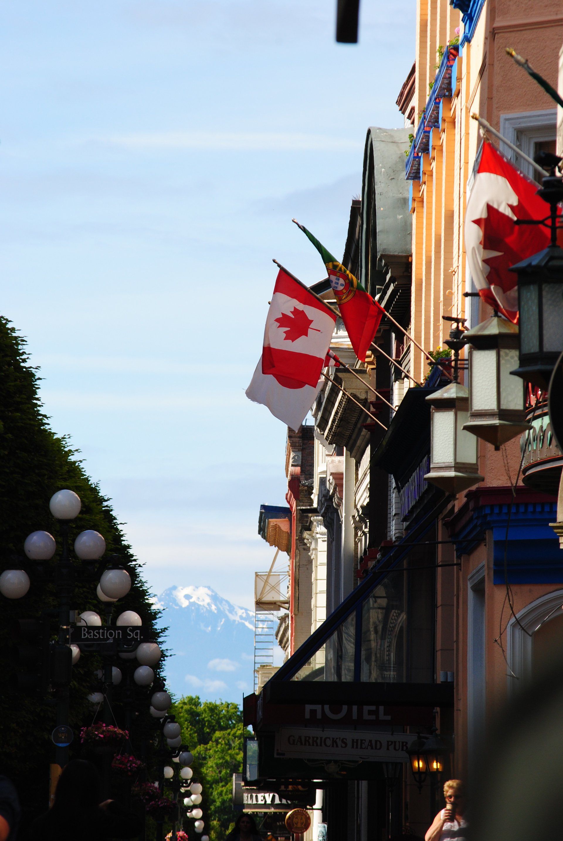 A canadian flag is hanging from the side of a building