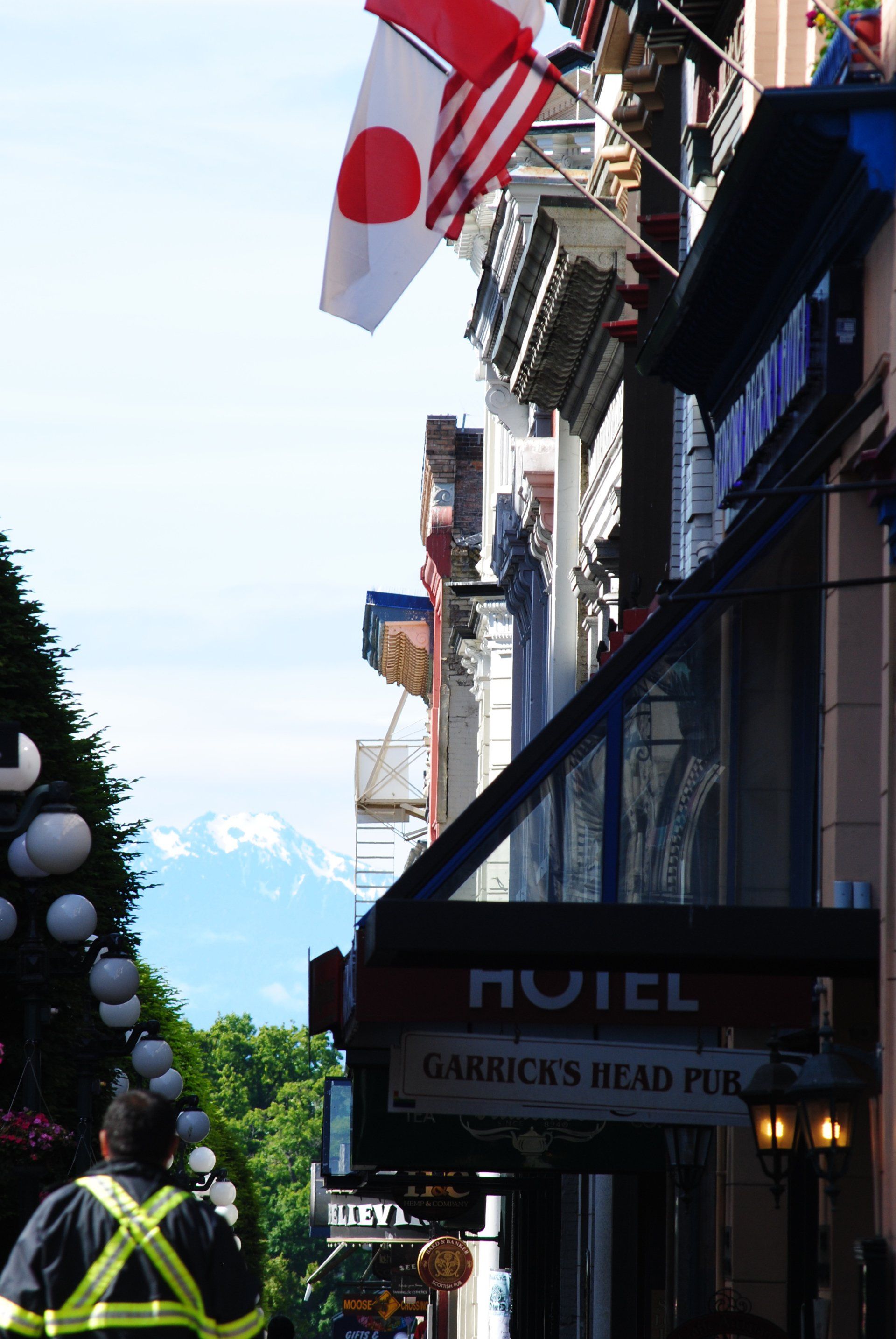 A man walking down a street with a sign that says garrick 's head pub