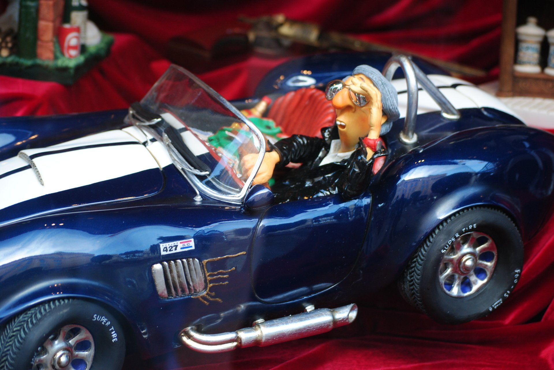 A blue and white sports car with a man in the driver 's seat