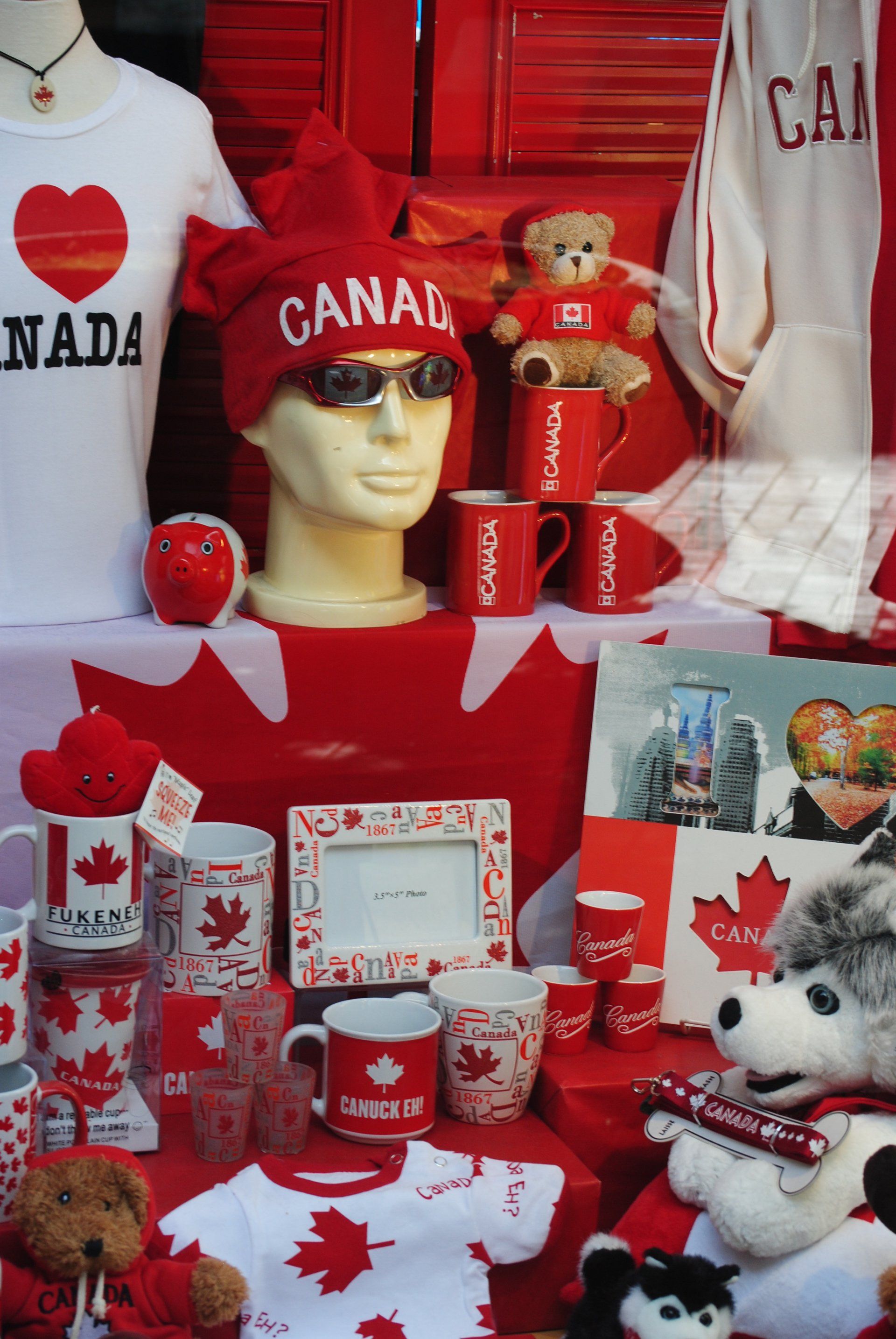 A display of canadian souvenirs including a hat that says canada