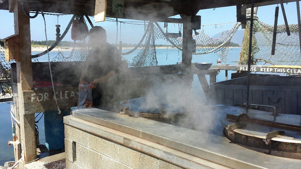 A man is standing in front of a stove with steam coming out of it.