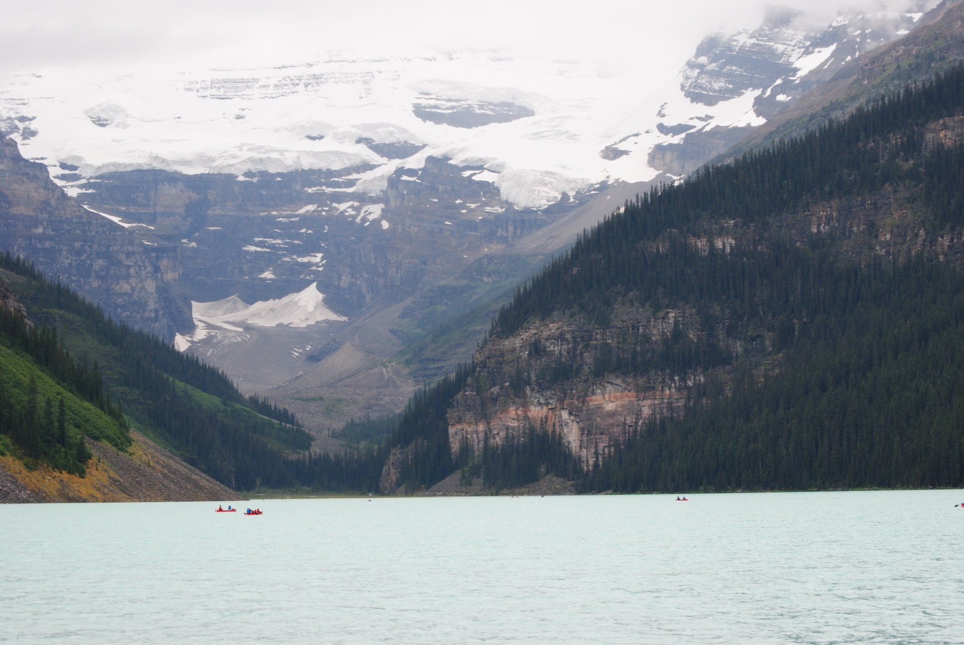 A lake surrounded by snow covered mountains and trees