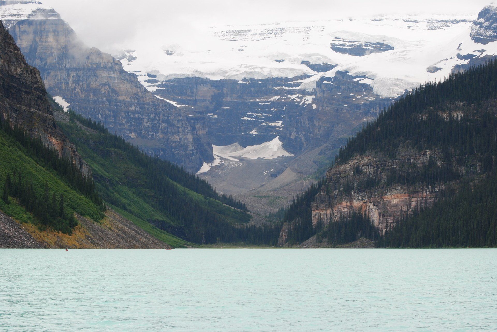 A lake surrounded by mountains with snow on them