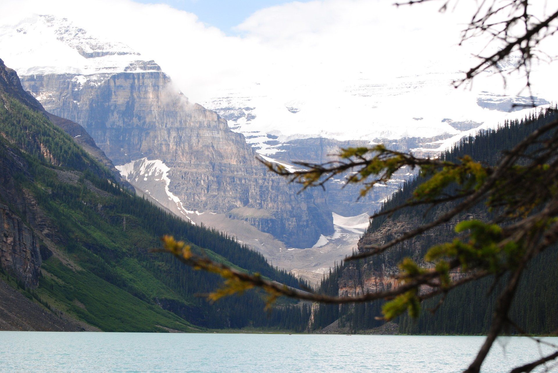 A lake with mountains in the background and trees in the foreground