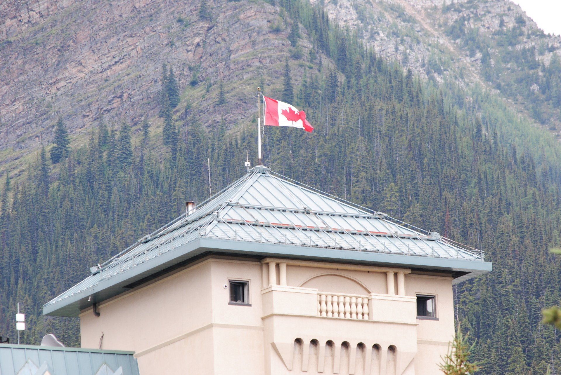 A canadian flag is flying on top of a building