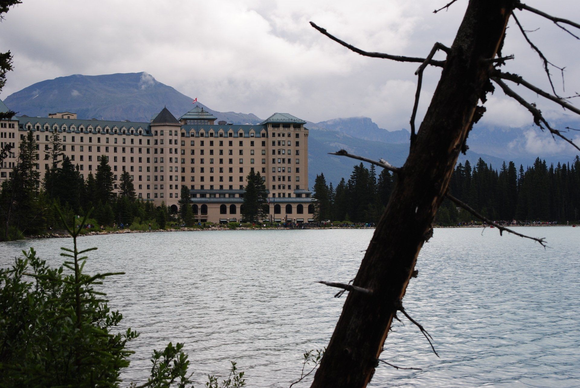 A large building sits on the shore of a lake