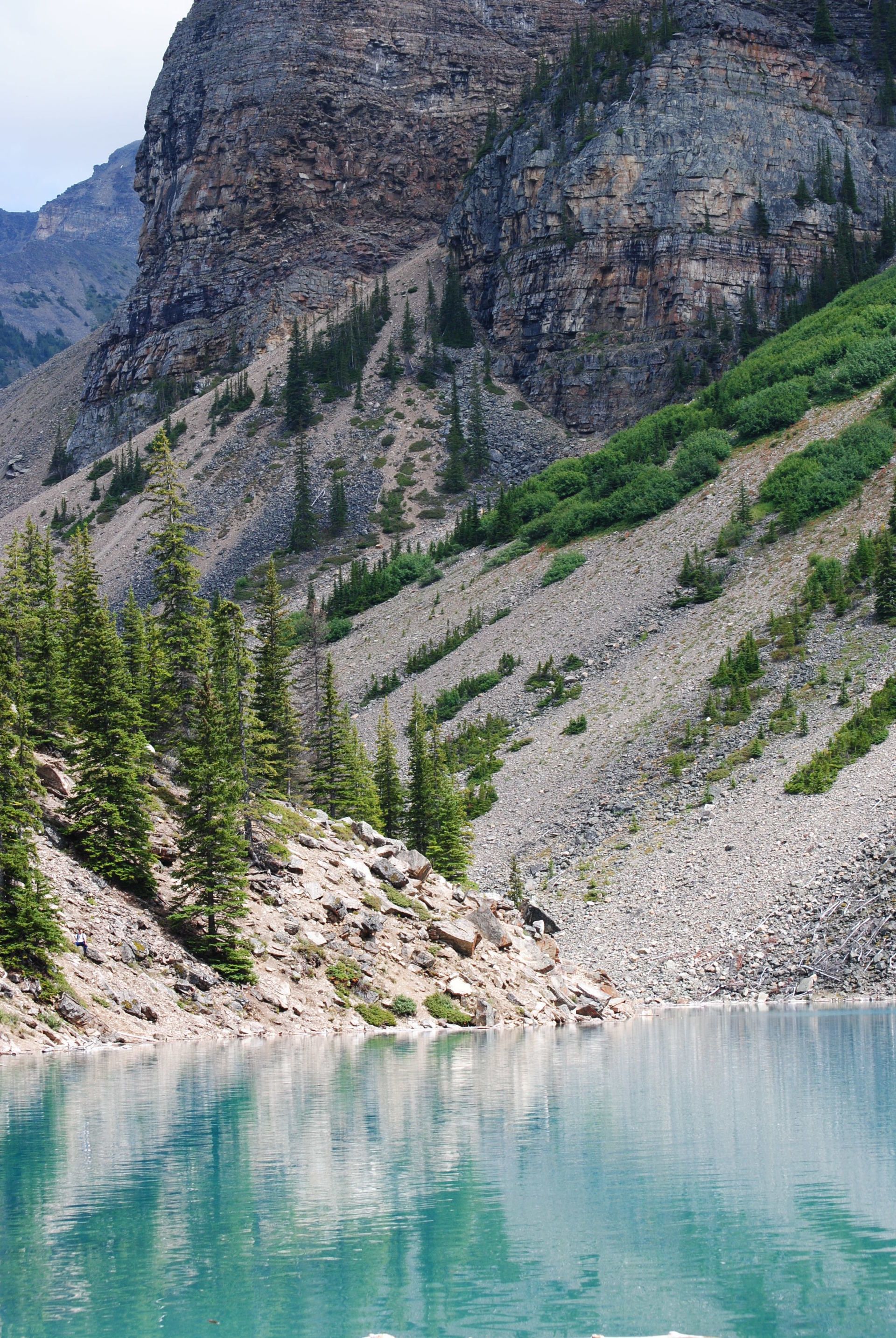 A lake surrounded by mountains and trees with a mountain in the background