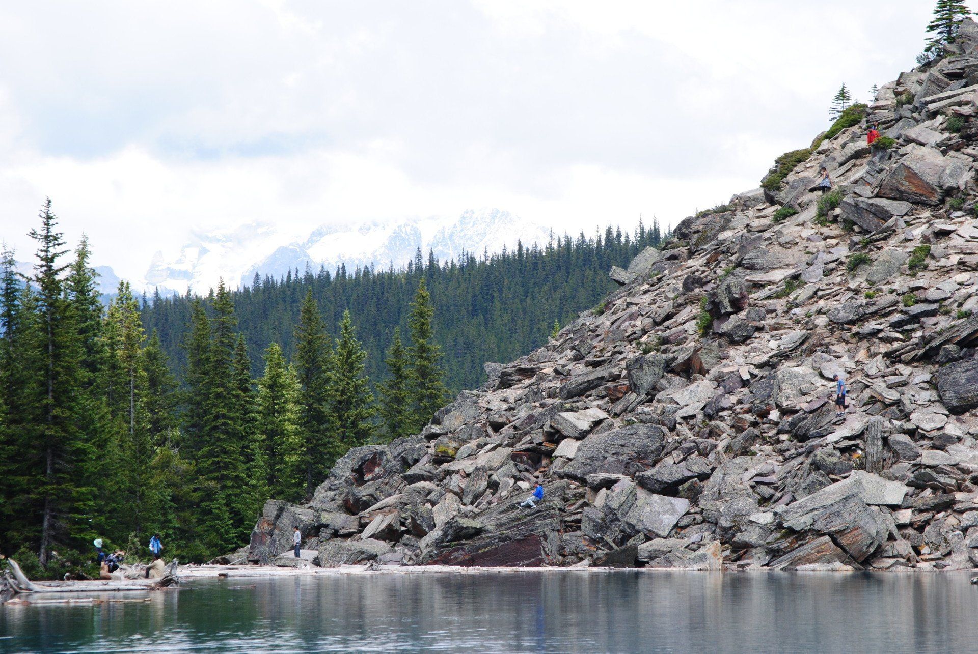 A lake surrounded by rocks and trees with a mountain in the background