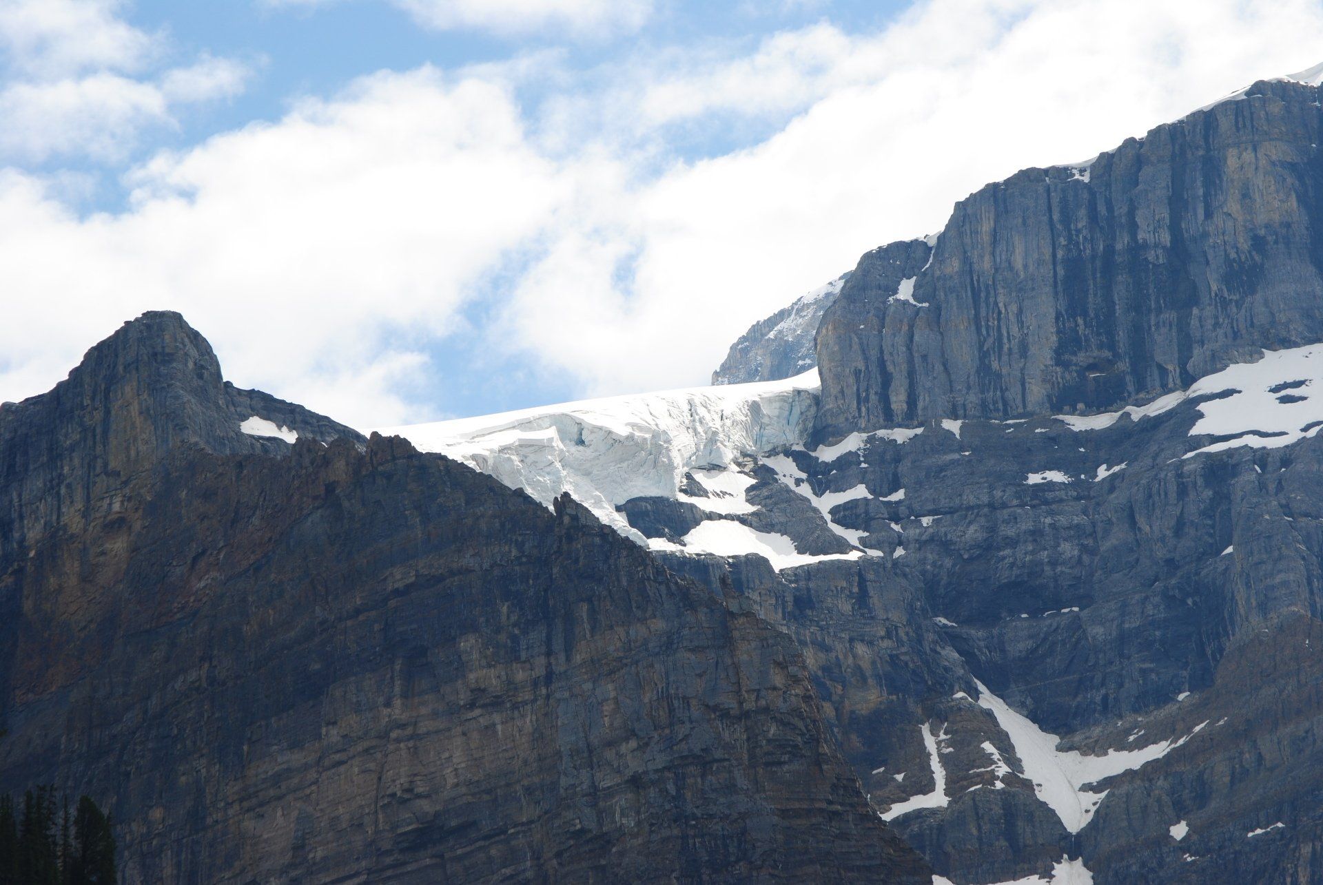 A mountain covered in snow and ice with a blue sky in the background