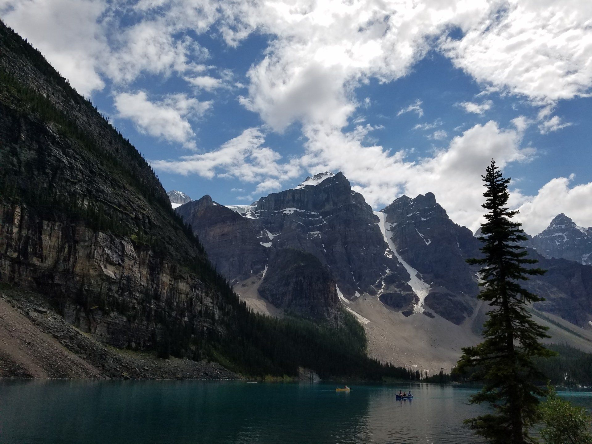 A lake surrounded by mountains on a cloudy day