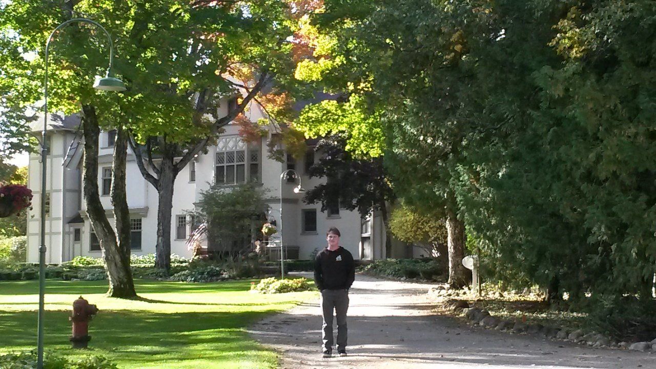 A man is walking down a path in front of a house