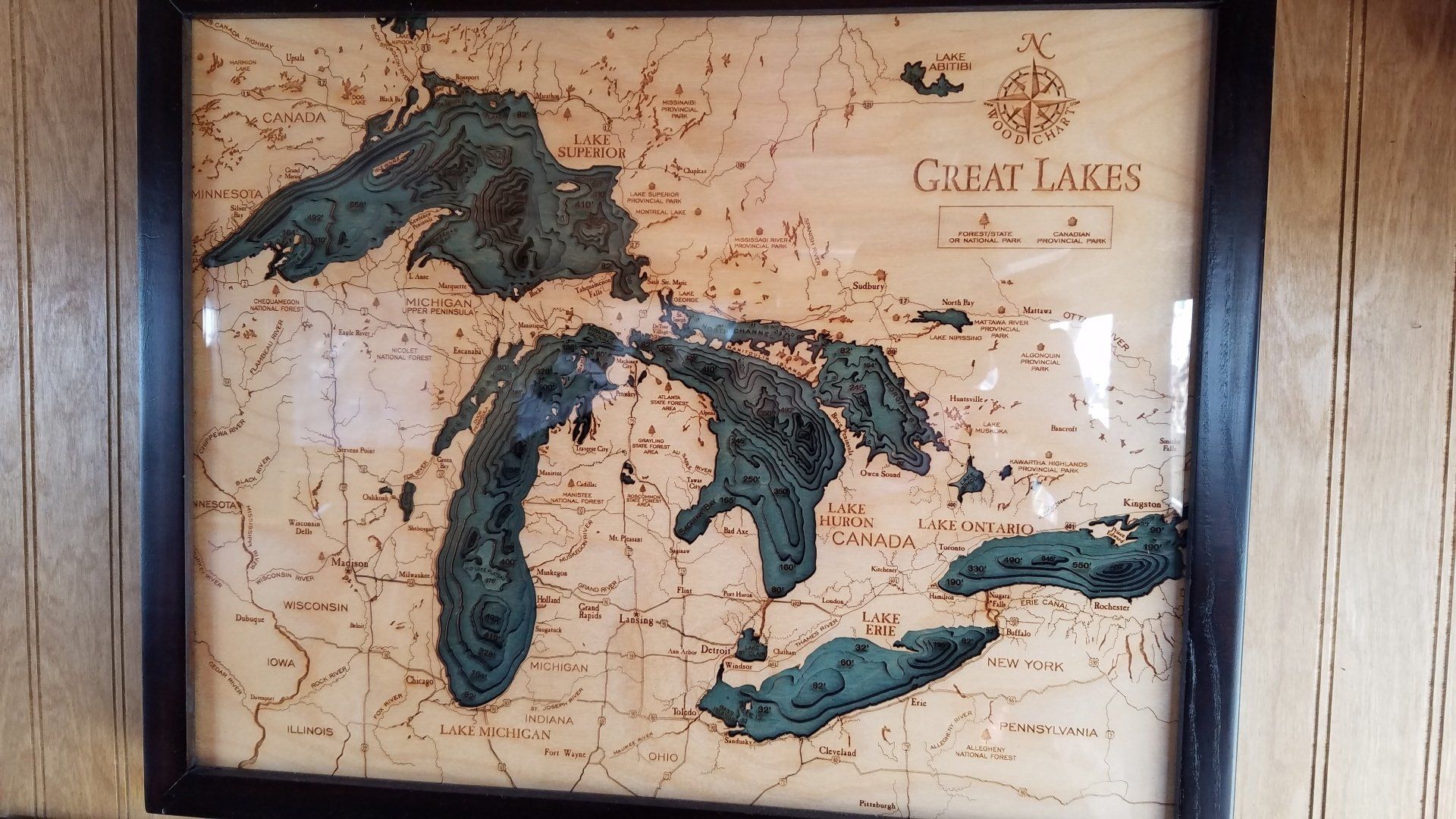 A map of the great lakes is framed on a wall