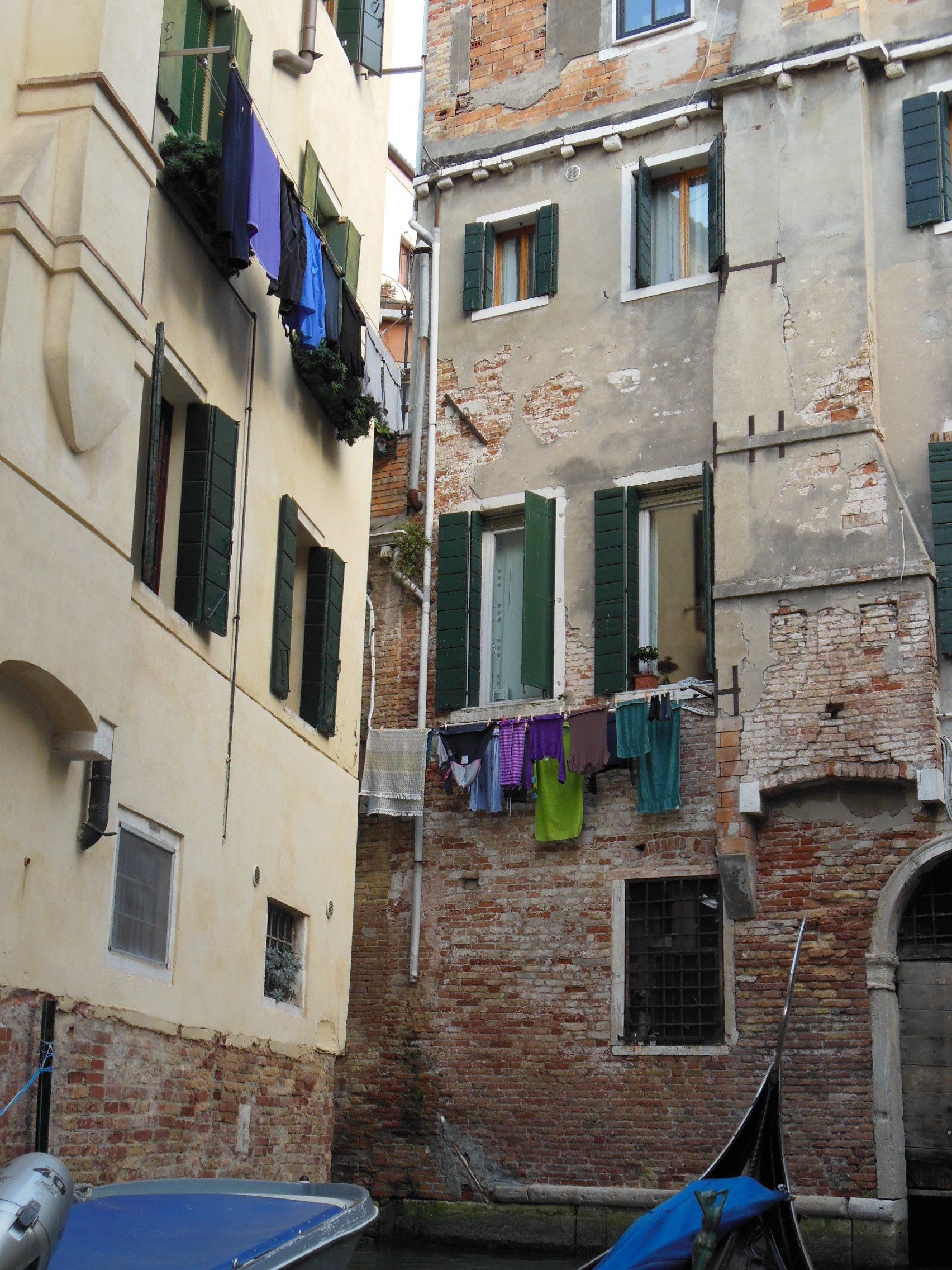 A boat is parked in front of a building with green shutters