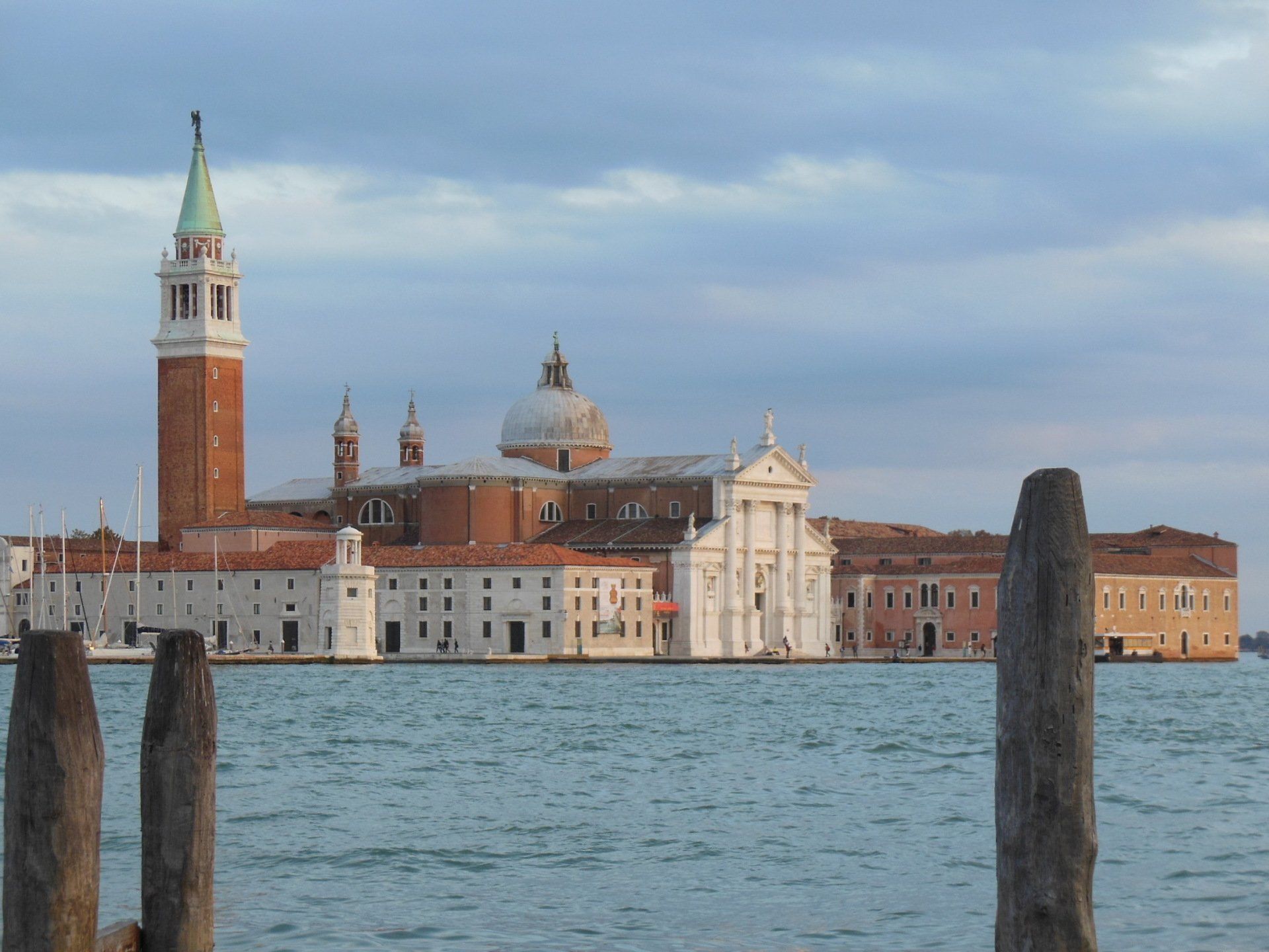 A large building with a bell tower in the middle of a body of water