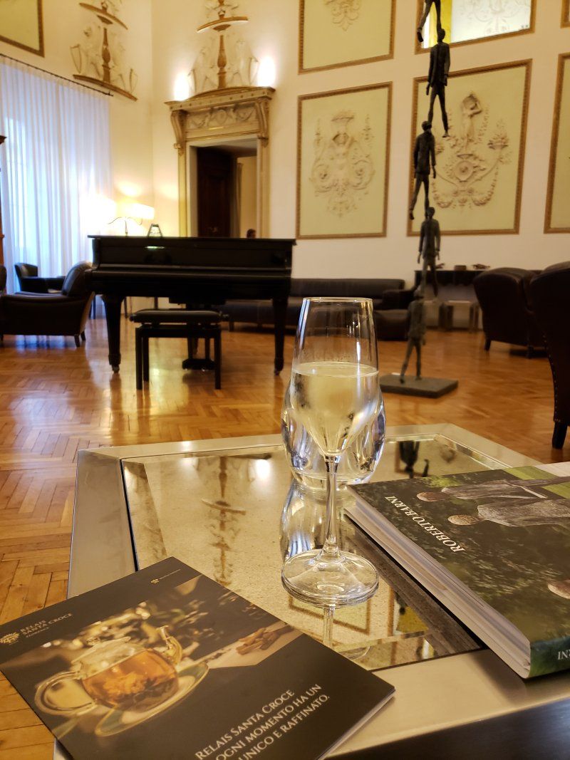 A living room with a piano and a glass of wine