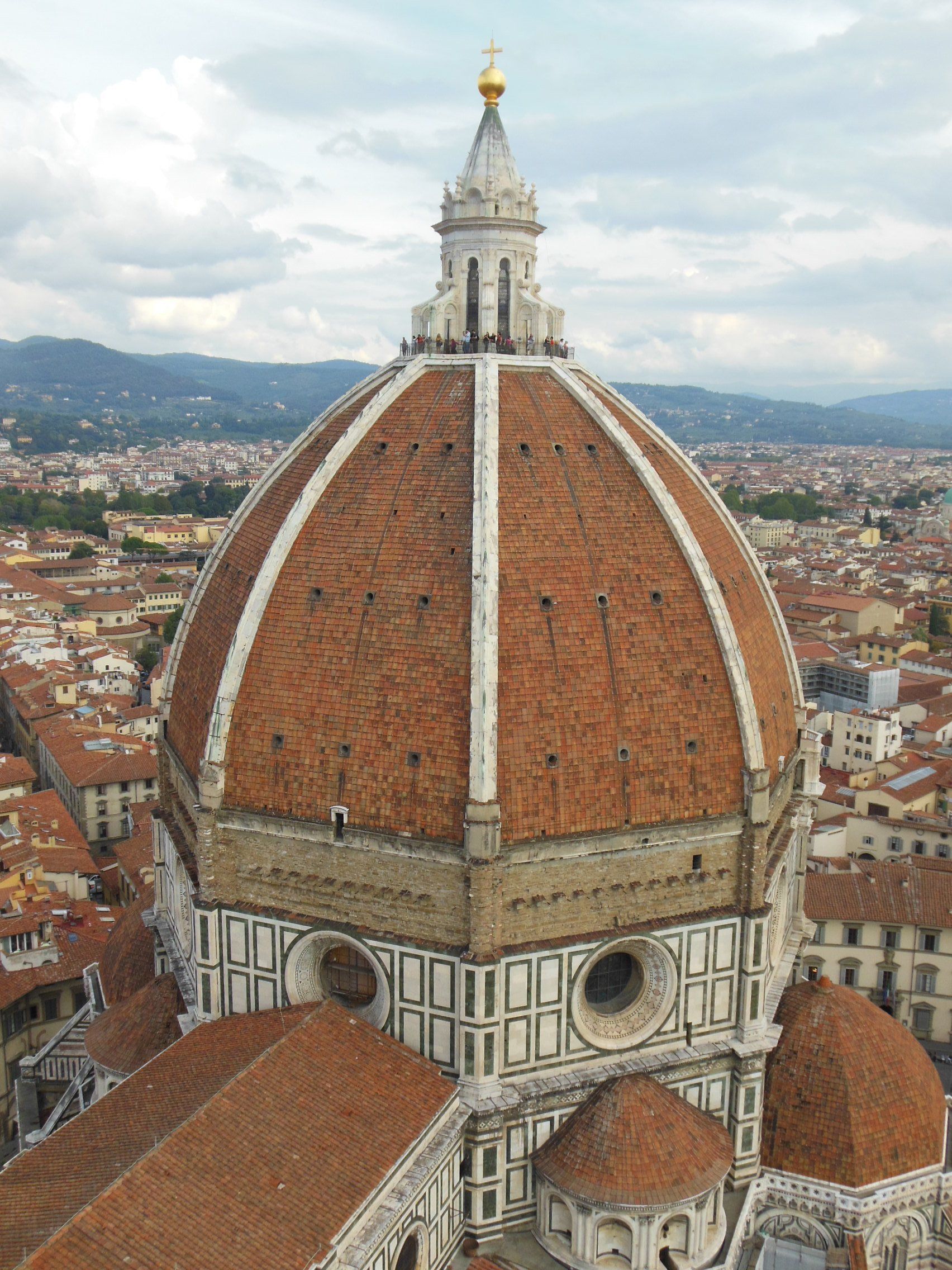 A dome of a building with a city in the background