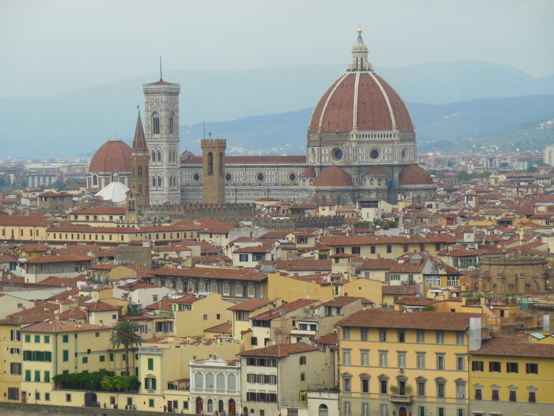 An aerial view of a city with a dome in the background